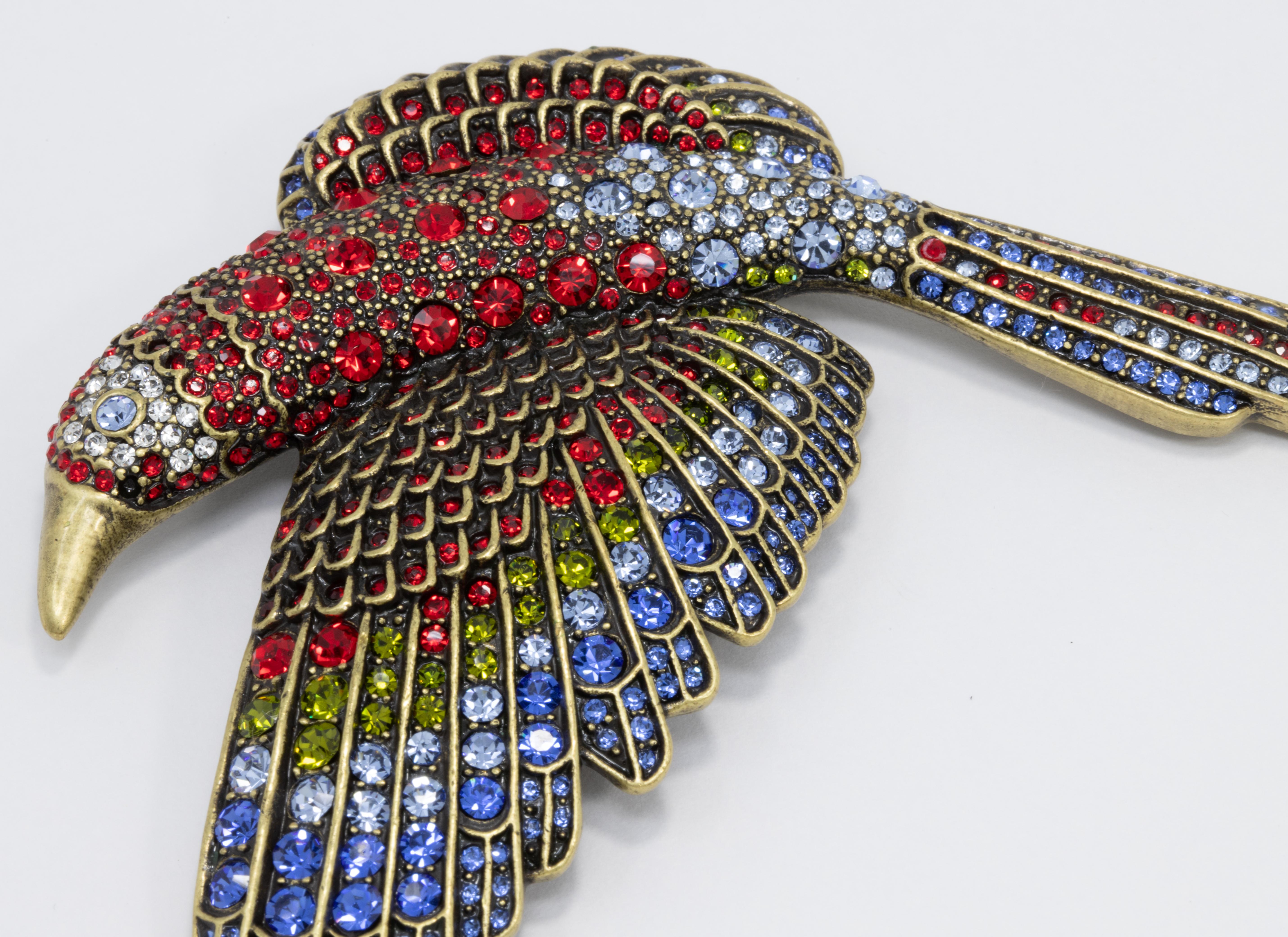 An exotic tropical parrot pin by Heidi Daus. This glamorous brooch is decorated with ruby, sapphire, aquamarine, and olivine crystals. Bring a stylish touch of the tropics to any outfit!

Marks / hallmarks / etc: Heidi Daus, CN