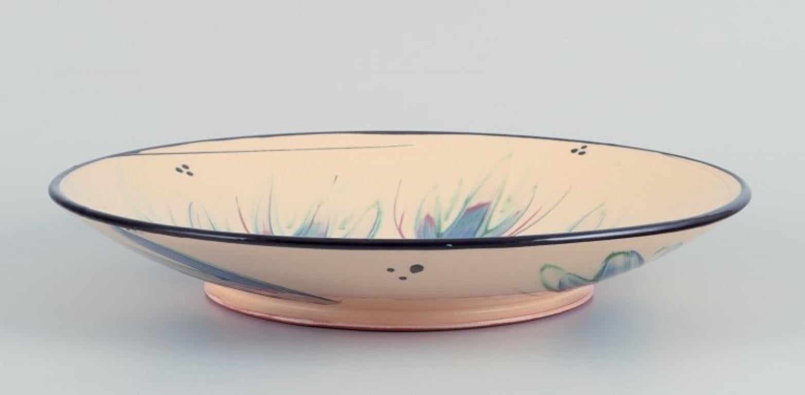 Heidi Fournier for Kähler, Denmark. 
Large ceramic bowl. Floral motifs on a cream-coloured base.
Approximately from the 1960s.
In perfect condition with natural crackling from production.
Marked.
Dimensions: D 32.5 cm x H 5.5 cm.