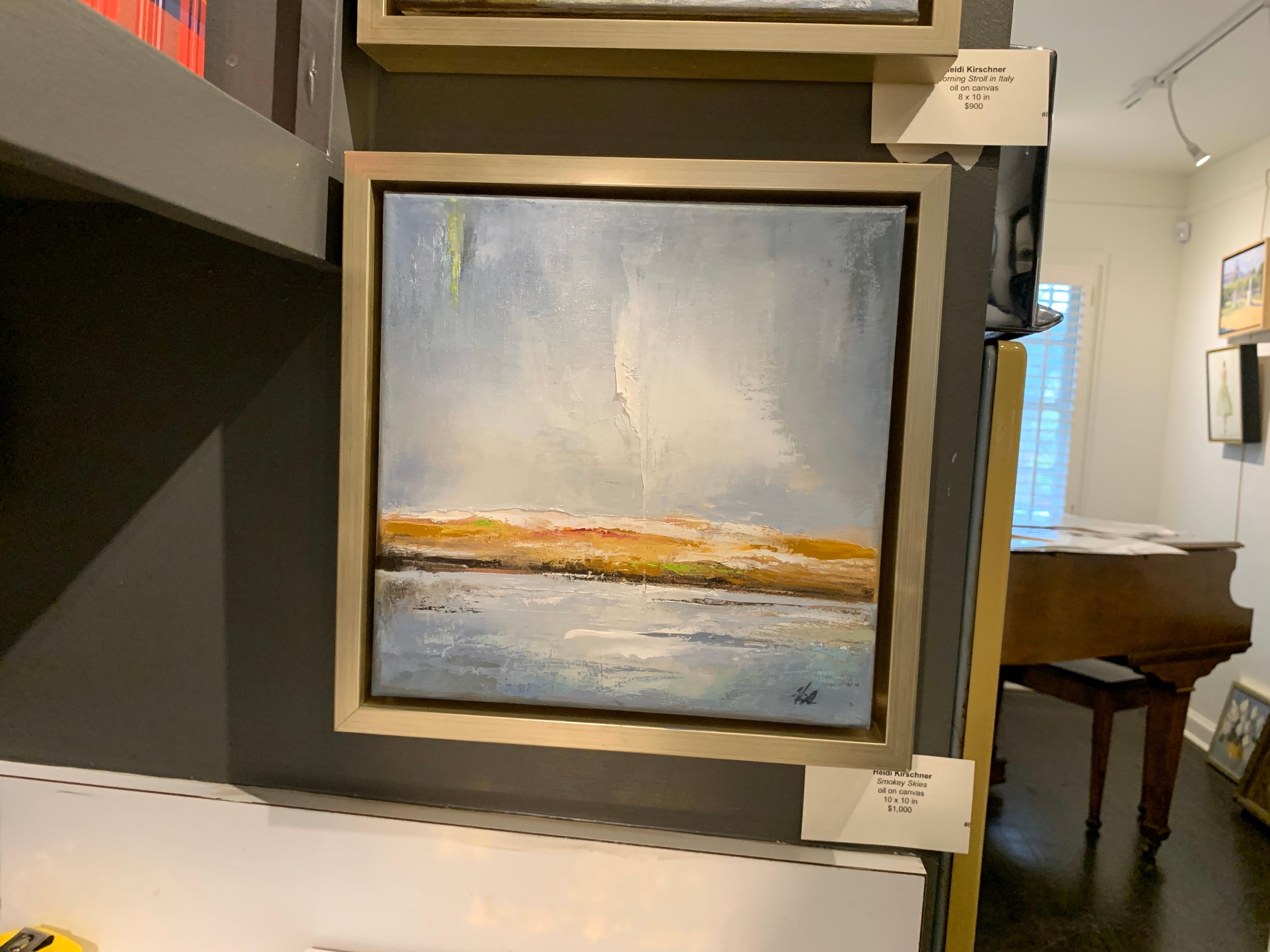 'Smokey Skies' is a framed oil on canvas landscape painting created by America artist Heidi Kirschner in 2020. Featuring a soft palette mostly made of a variation of pale blue, brown and green tones accented with subtle touches of white, the