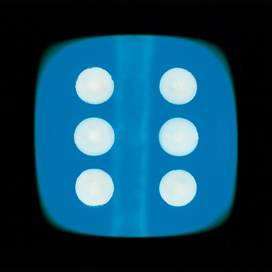 A blue dice suspended on a black background, hypnotically curious in both content and technique, viewers find themselves pleasantly puzzled. Heidler & Heeps have developed their own dichromatic technique resulting in something, which is neither a