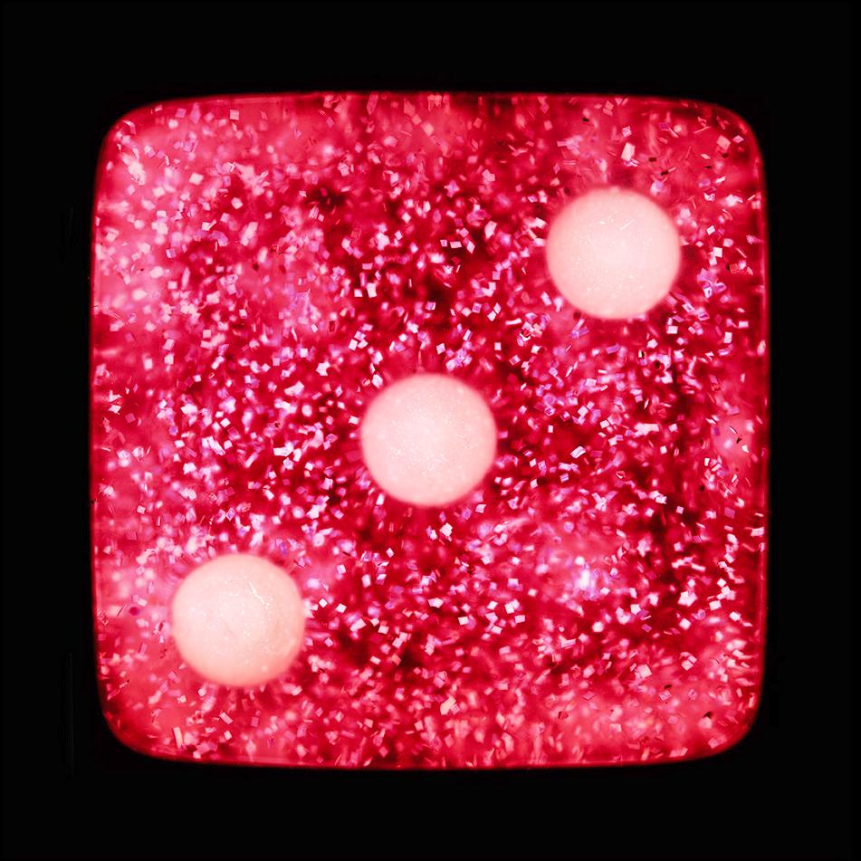A sparkly pink dice suspended on a black background, hypnotically curious in both content and technique, viewers find themselves pleasantly puzzled. Heidler & Heeps have developed their own dichromatic technique resulting in something, which is