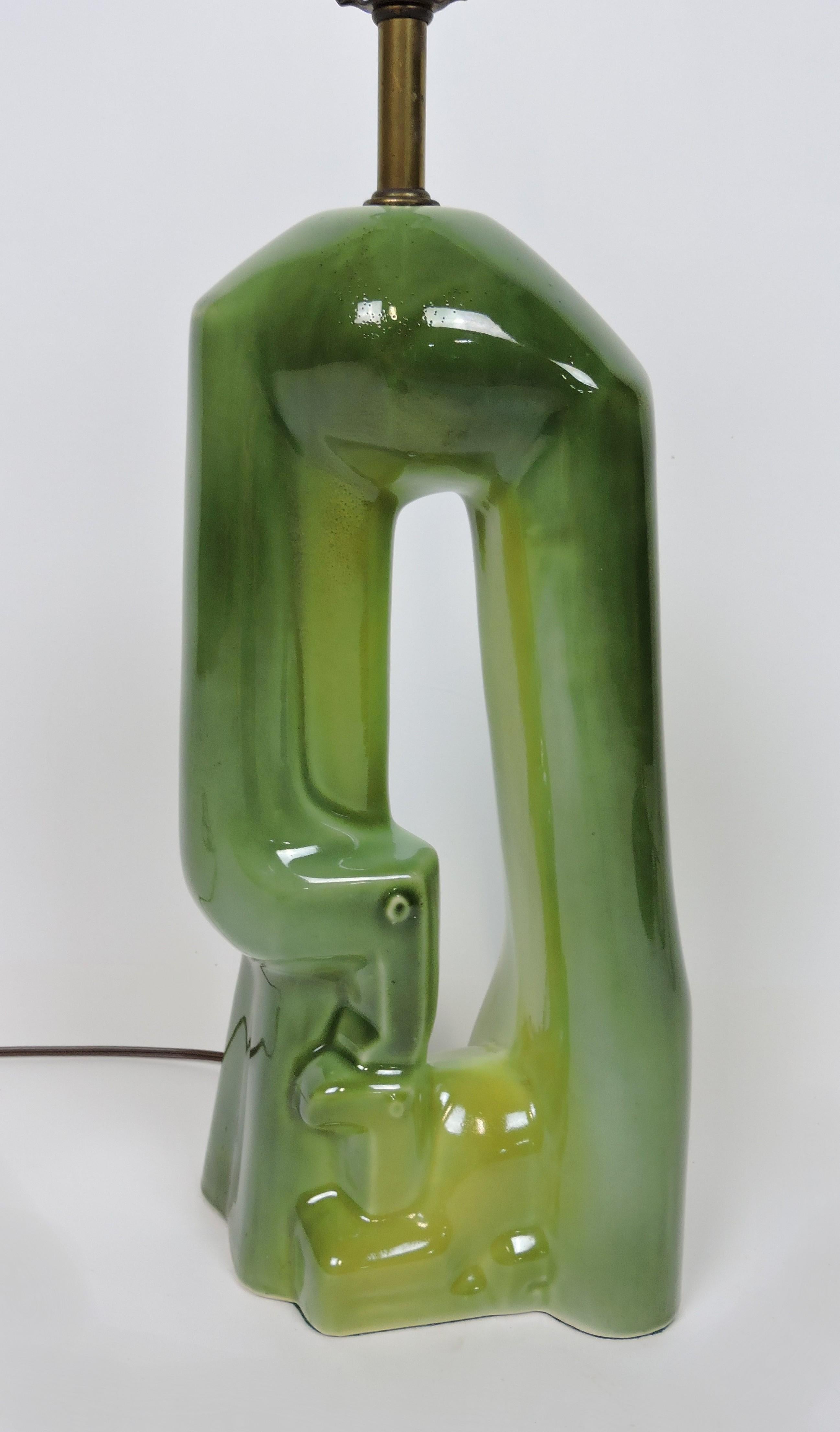 Charming ceramic table lamp in the style of Yasha Heifetz. This sculptural lamp is a highly stylized and abstracted image of a mother and baby giraffe and has a beautiful variegated green glaze.  It has all new wiring and takes a 3-way bulb.