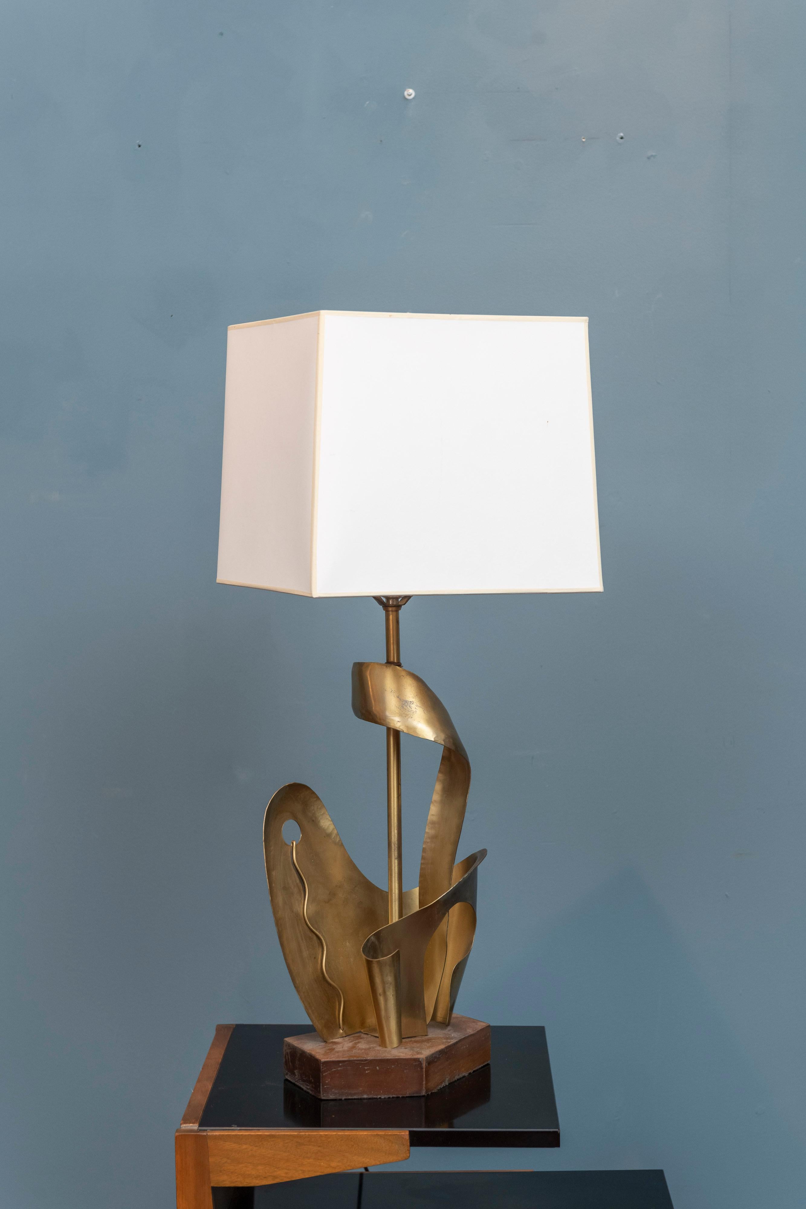 Yasha Heifetz design table lamp, U.S.A. Abstract hammered brass sculpture body on an asymmetrical wood base. Well executed with a skilled eye and craftsmanship, signed base and a documented model by Heifetz Lighting.