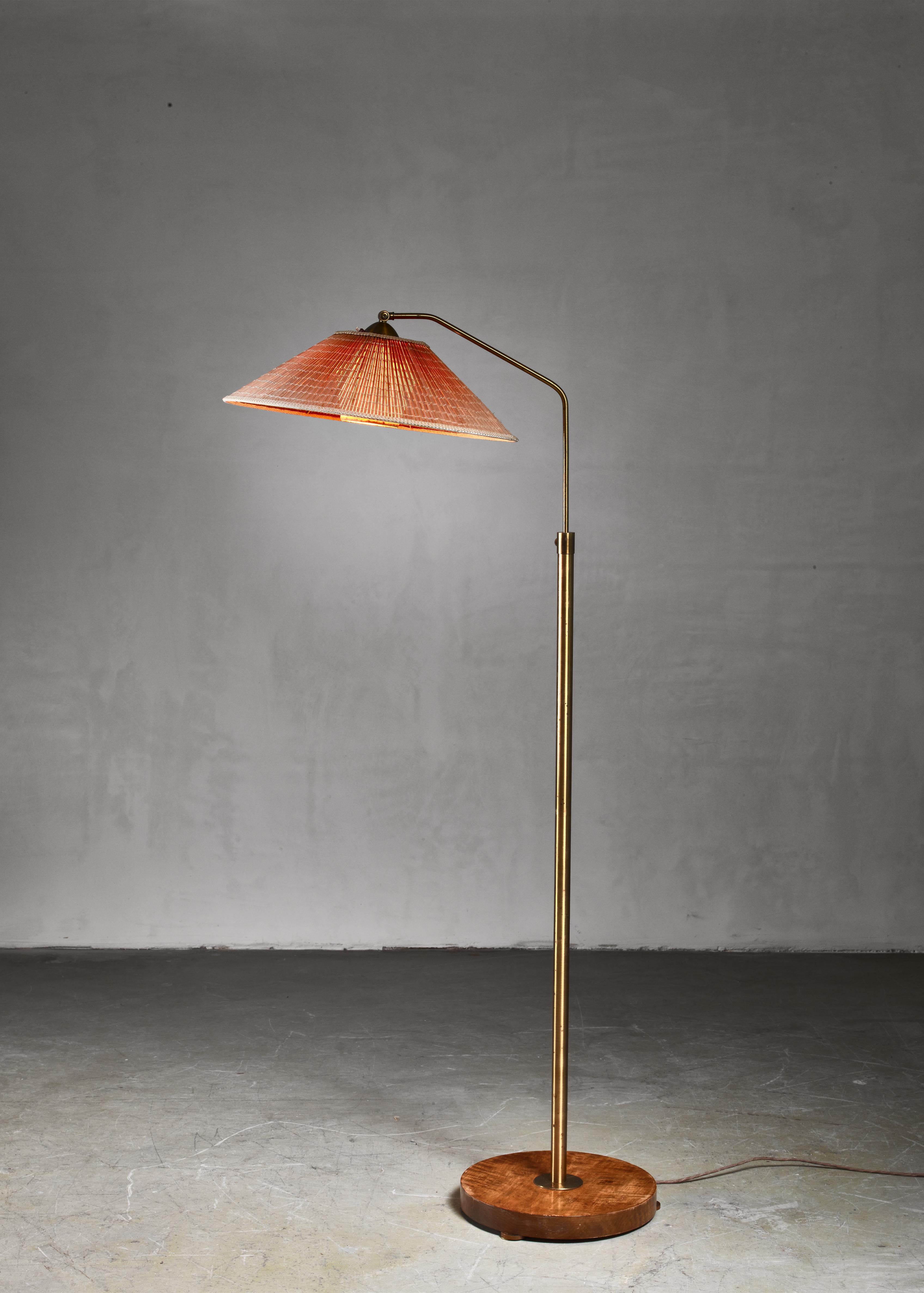 A height-adjustable Swedish floor lamp with an adjustable wood slat shade and a paper diffuser. The lamp has a brass stem and stands on a round root wood foot.

The height can be adjusted between 136 and 193 cm.