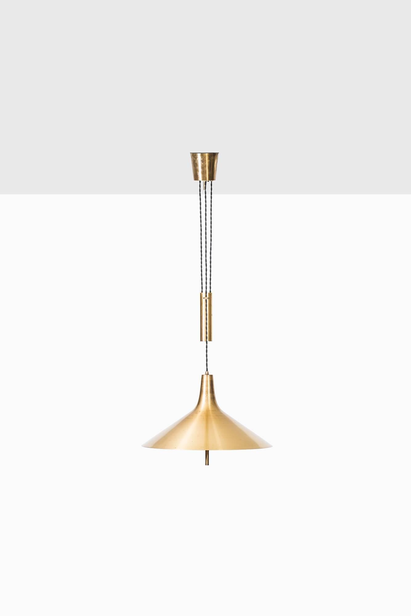 Rare height adjustable ceiling lamp in brass. Produced in Denmark.