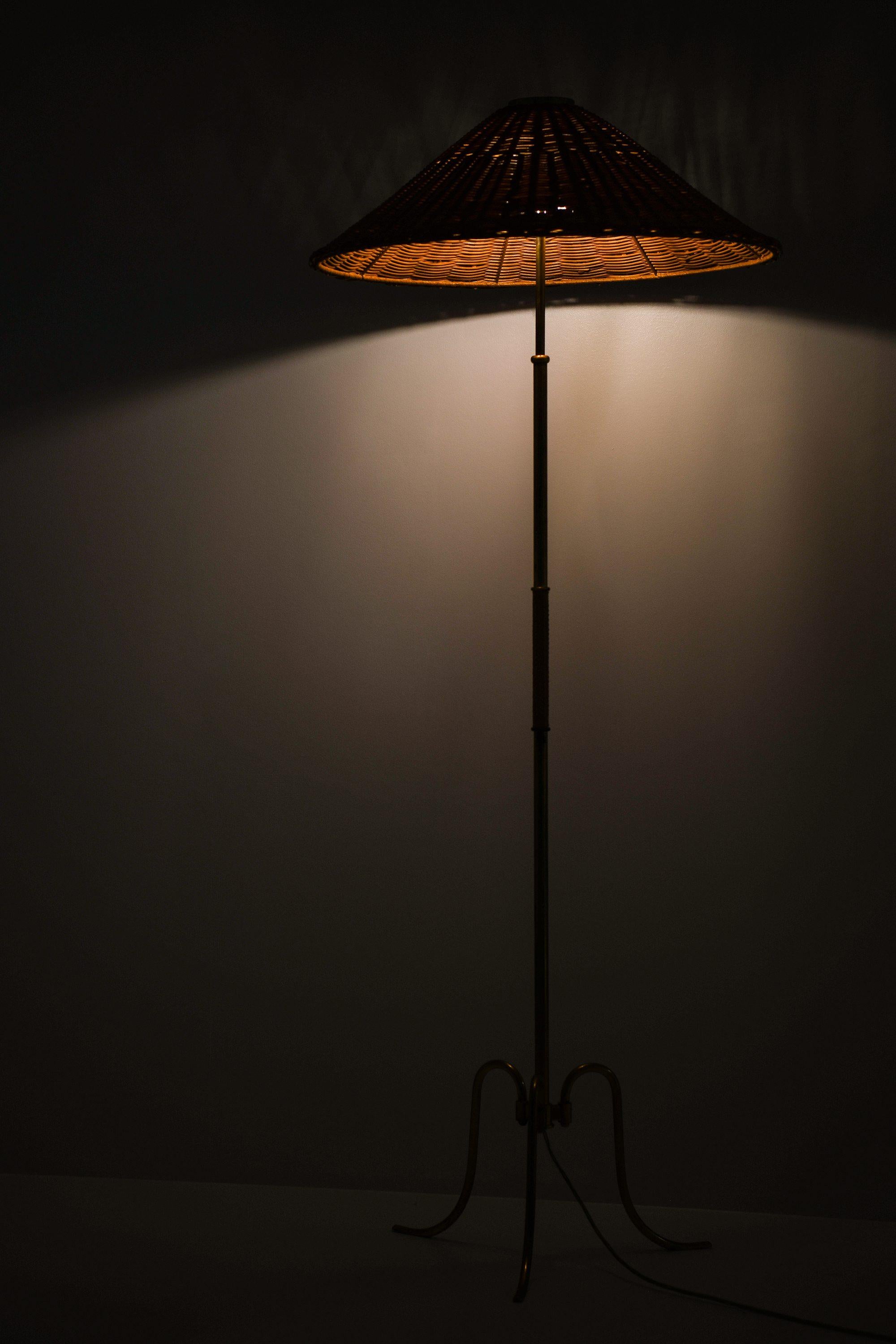 Ottone Lampada da terra regolabile in altezza in ottone, canna intrecciata e paralume in rattan, anni '40 in vendita