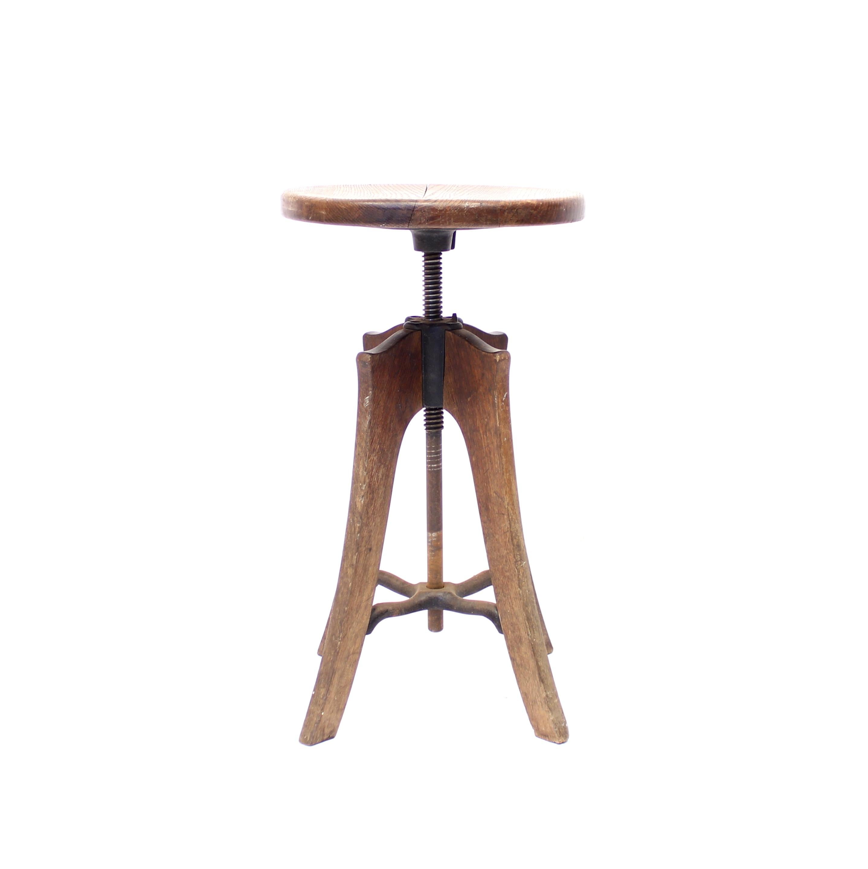 Industrial and height adjustable barstool of oak and wrought iron from the early part of 1900s. It's taller than a normal dining chair so it would work perfect as a bar stool or work stool. It can be height adjustable between 60-74 cm. Overall in a