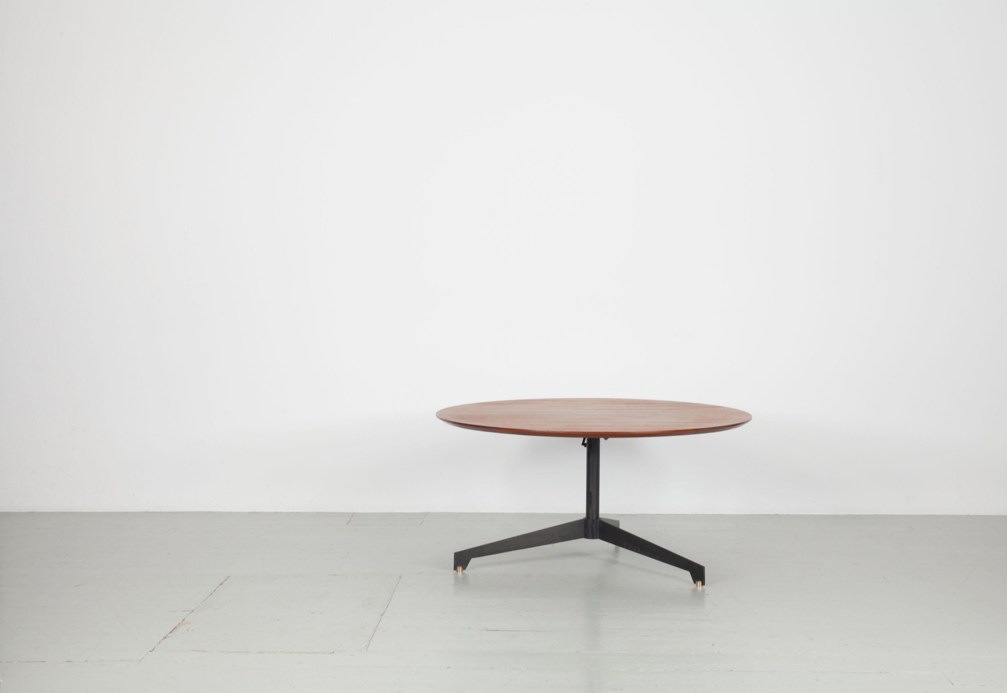 Height adjustable round teakwood table from the Italian, 1950s.

The ingenious mechanism for height adjustment is activated by a lever under the table that drives the pump located in the central shaft. When the desired height is set, the lever is