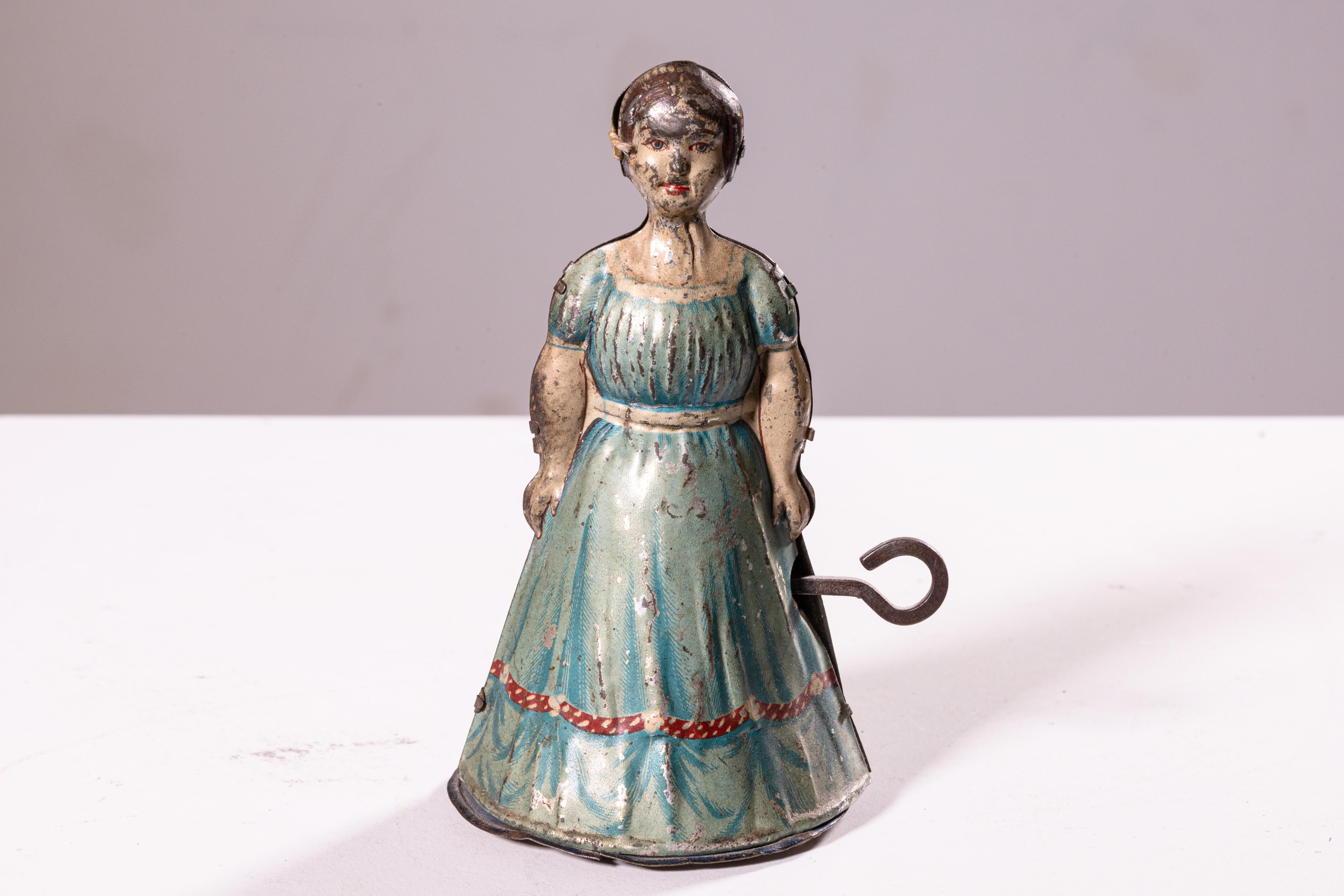 An antique windup tin toy depicting a woman or maid in an apron designed by Heinrich Fisher & Co. When the toy is wound with the key, the woman walks. Made in Germany, circa 1920s. A unique collector’s item. From a private collection. Dimensions: