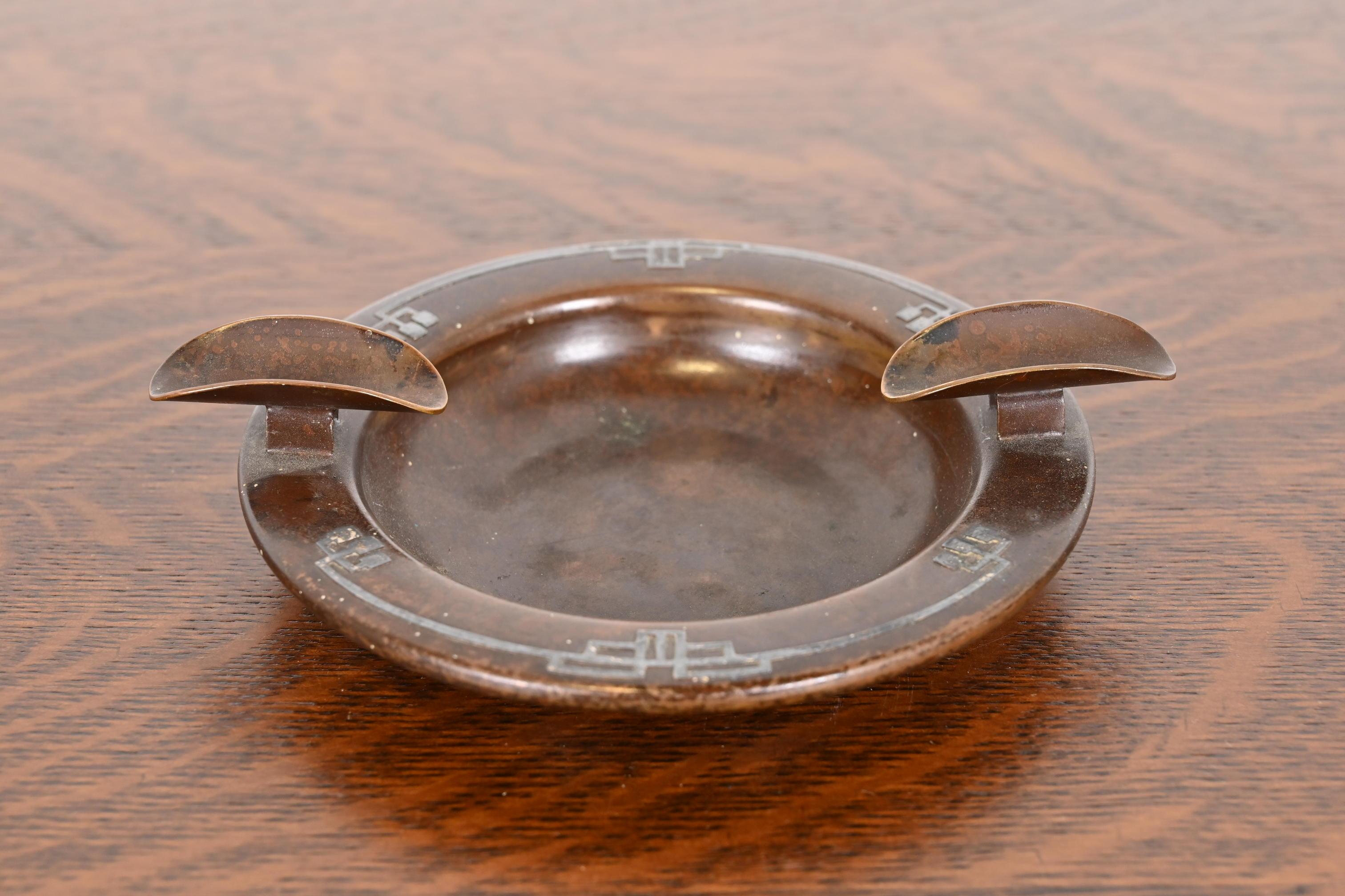 A gorgeous antique Arts & Crafts or Art Deco period sterling silver on bronze ashtray with cigar rest

By Heintz Art Metal Shop

USA, Early 20th Century

Measures: 6.75