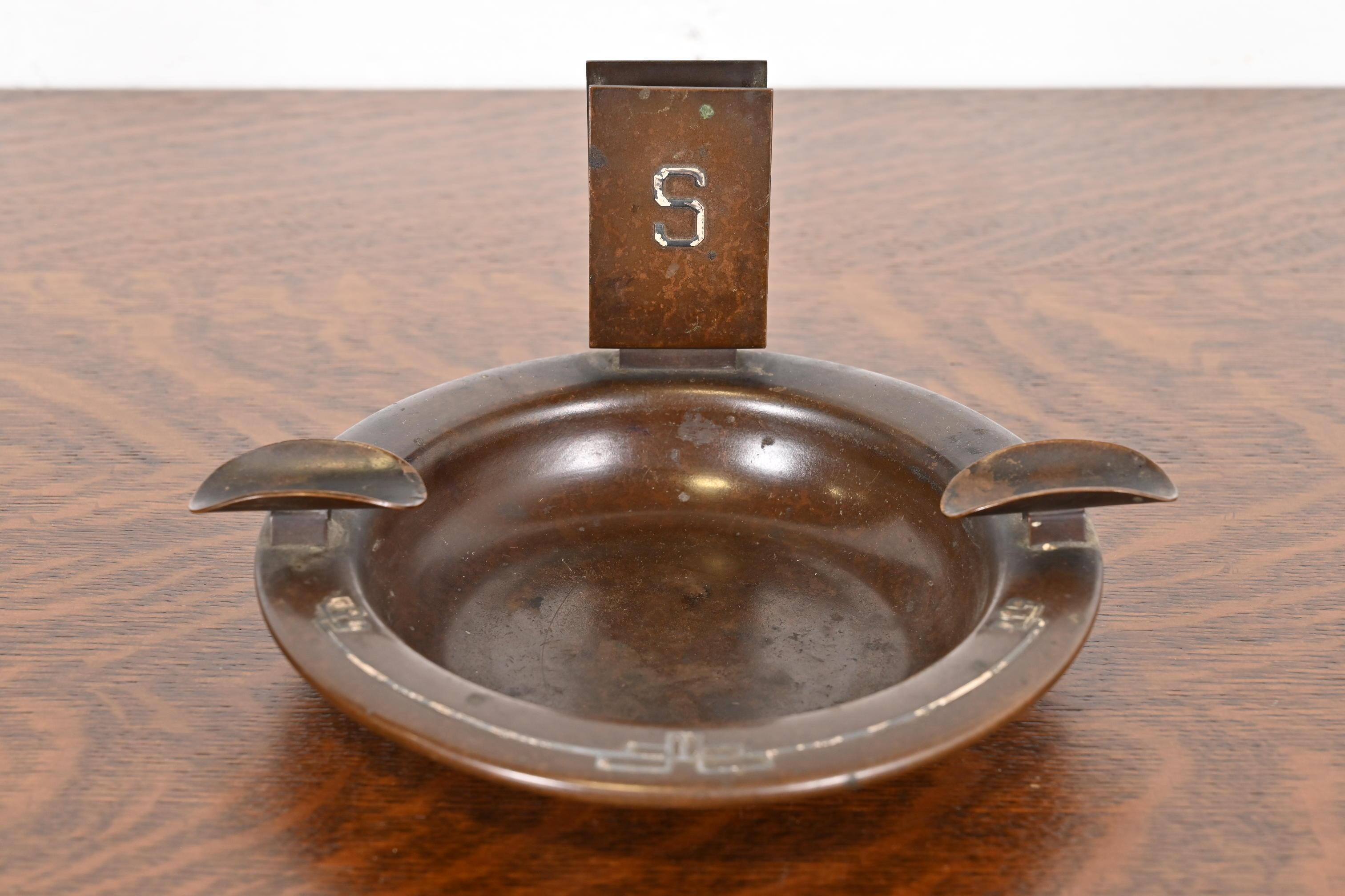 Precioso cenicero antiguo de época Arts & Crafts o Art Decó de plata de ley sobre bronce con caja para cerillas

Por Heintz Art Metal Shop

EE.UU., principios del siglo XX

Medidas: 8 
