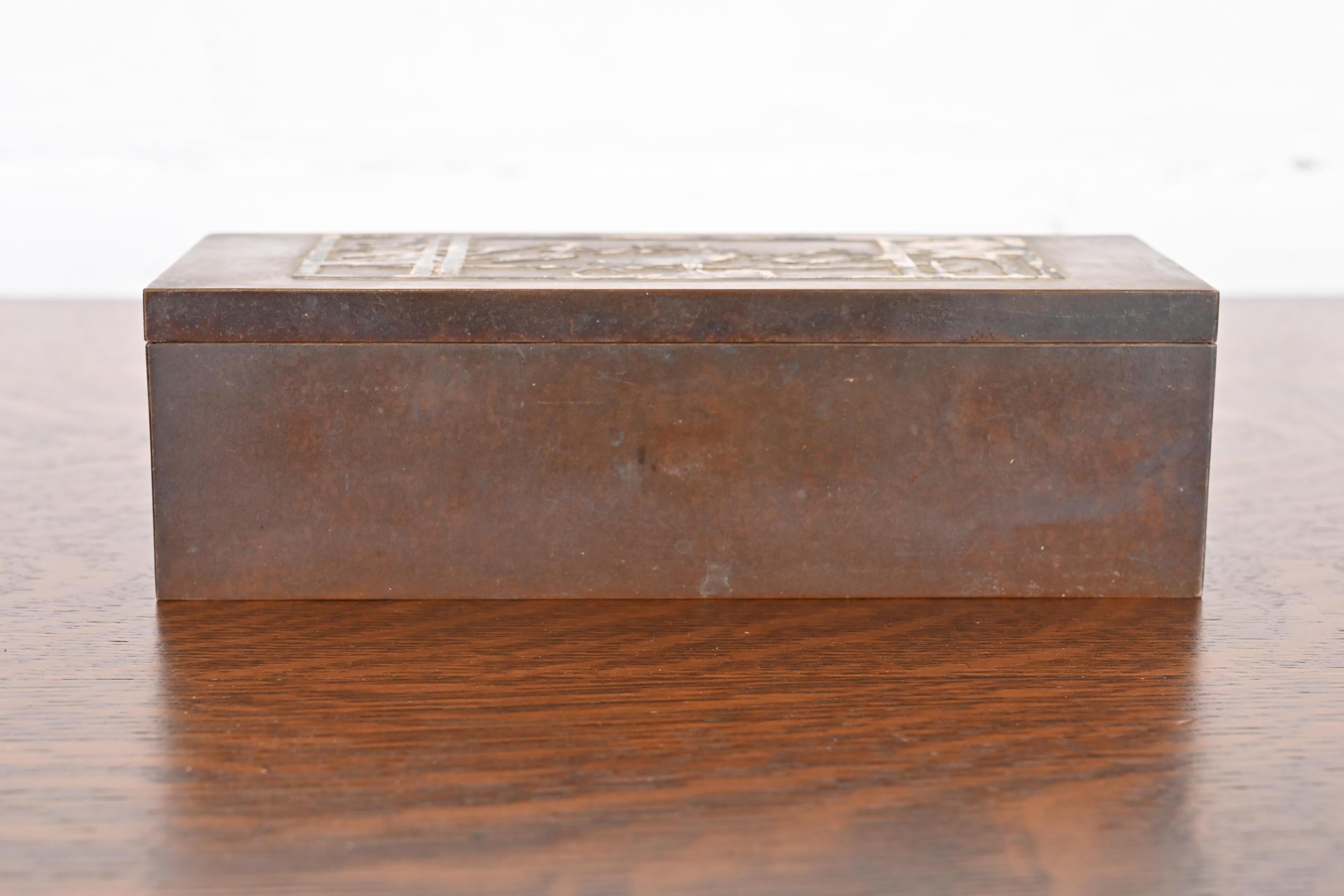Un precioso humidor o caja de puros de época Arts & Crafts

Por Heintz Art Metal Shop

EE.UU., principios del siglo XX

Plata de ley sobre bronce patinado, con interior forrado de cedro.

Medidas: 8,5