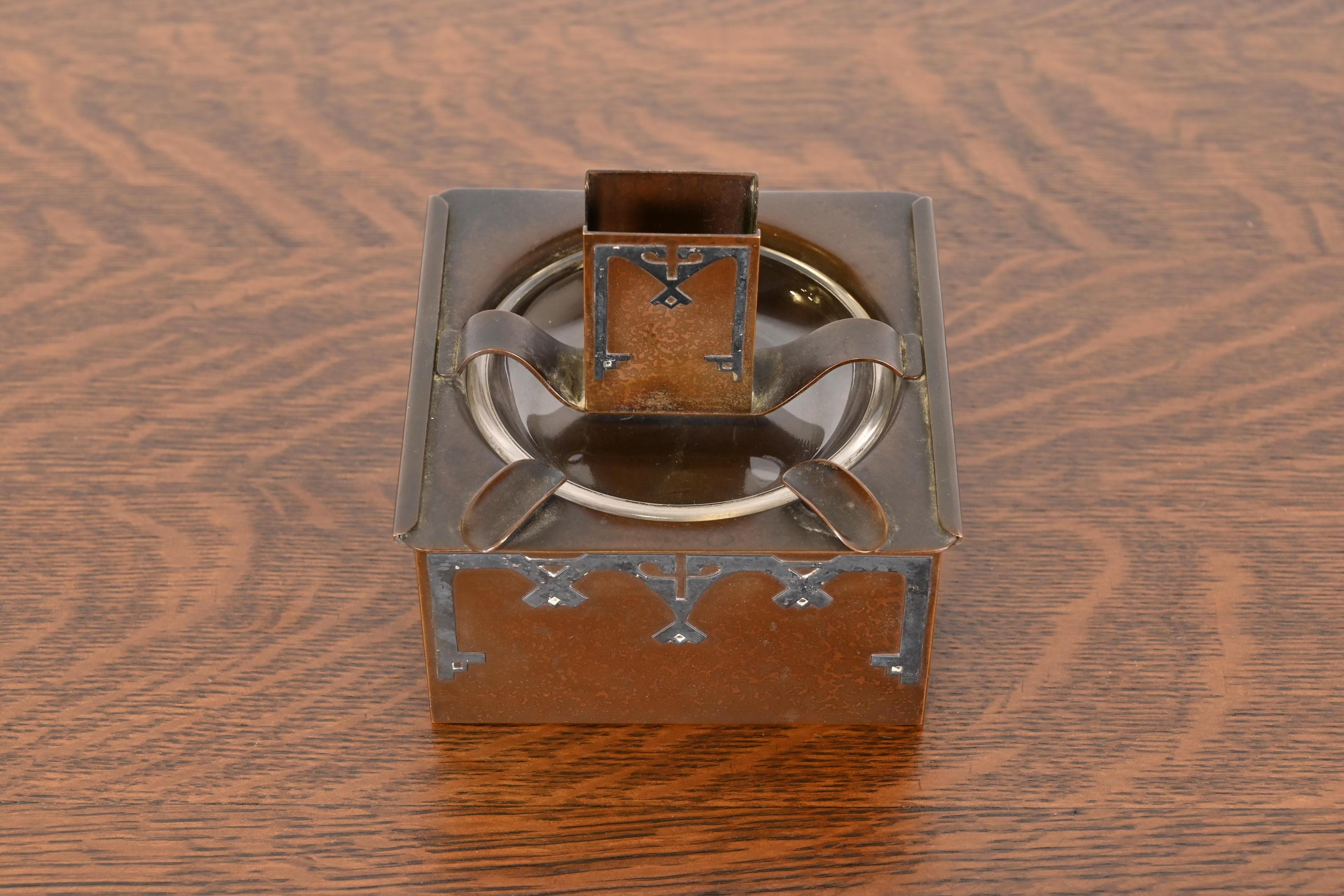 Ein prächtiger Humidor aus der Zeit des Arts & Crafts mit verschiebbarem Streichholzhalter und Aschenbecherdeckel

Von Heintz Art Metal Shop

USA, Anfang 20. Jahrhundert

Sterlingsilber auf patinierter Bronze, innen mit Zedernholz