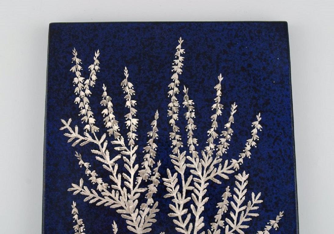 Heinz Erret (1920-2003) for Gustavsberg. 
Wall plaque in glazed ceramics with silver inlay in the form of heather. 1970s.
Measures: 33.5 x 21 cm.
In excellent condition.
Stamped.