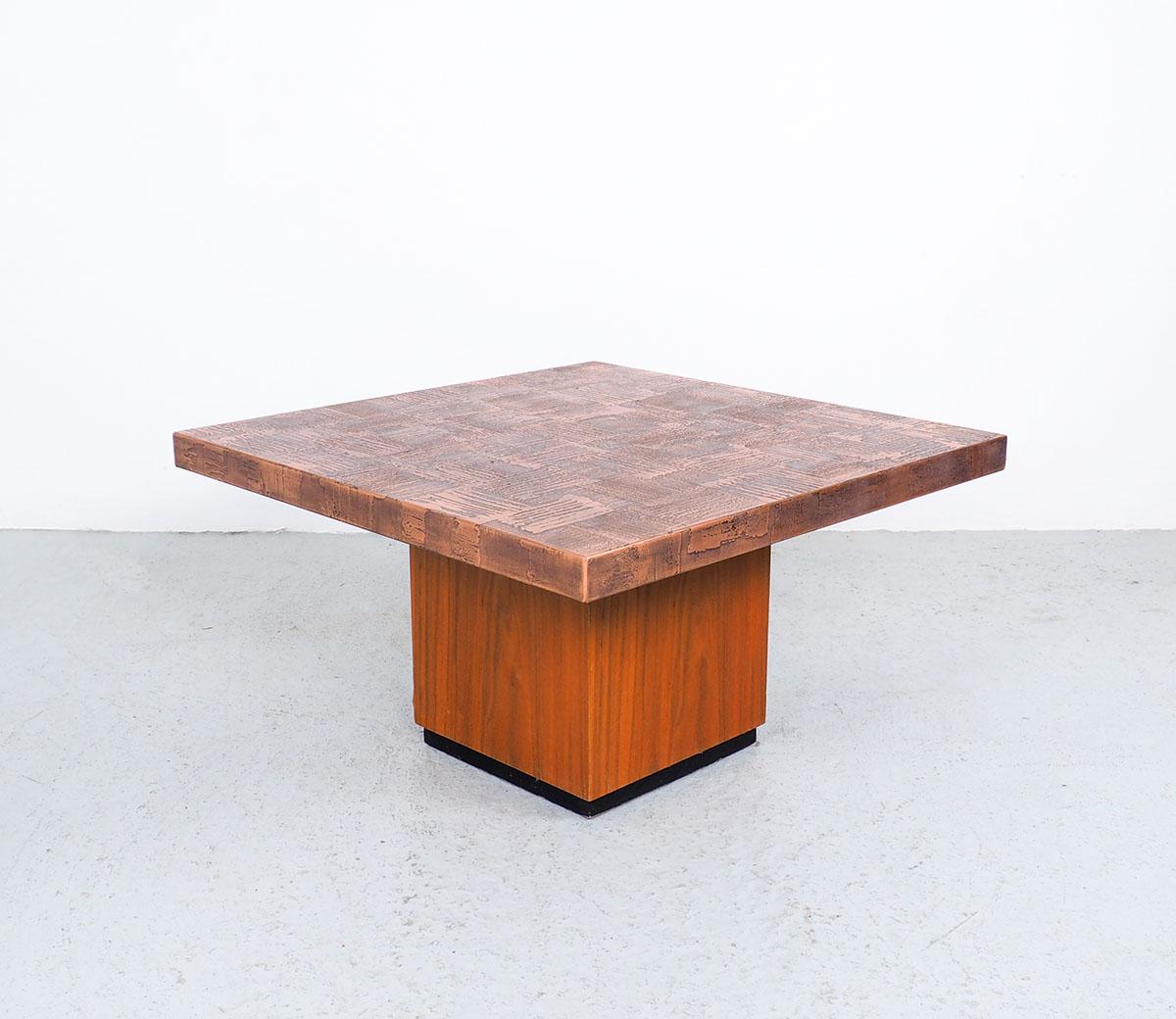 Vintage artistic brutalist square coffee table designed by the German artist Heinz Lilienthal (1927-2006).
Designed in the 1970s.
The table has an etched copper top with a teak wooden block base.
The table has a warm and sturdy look due to the