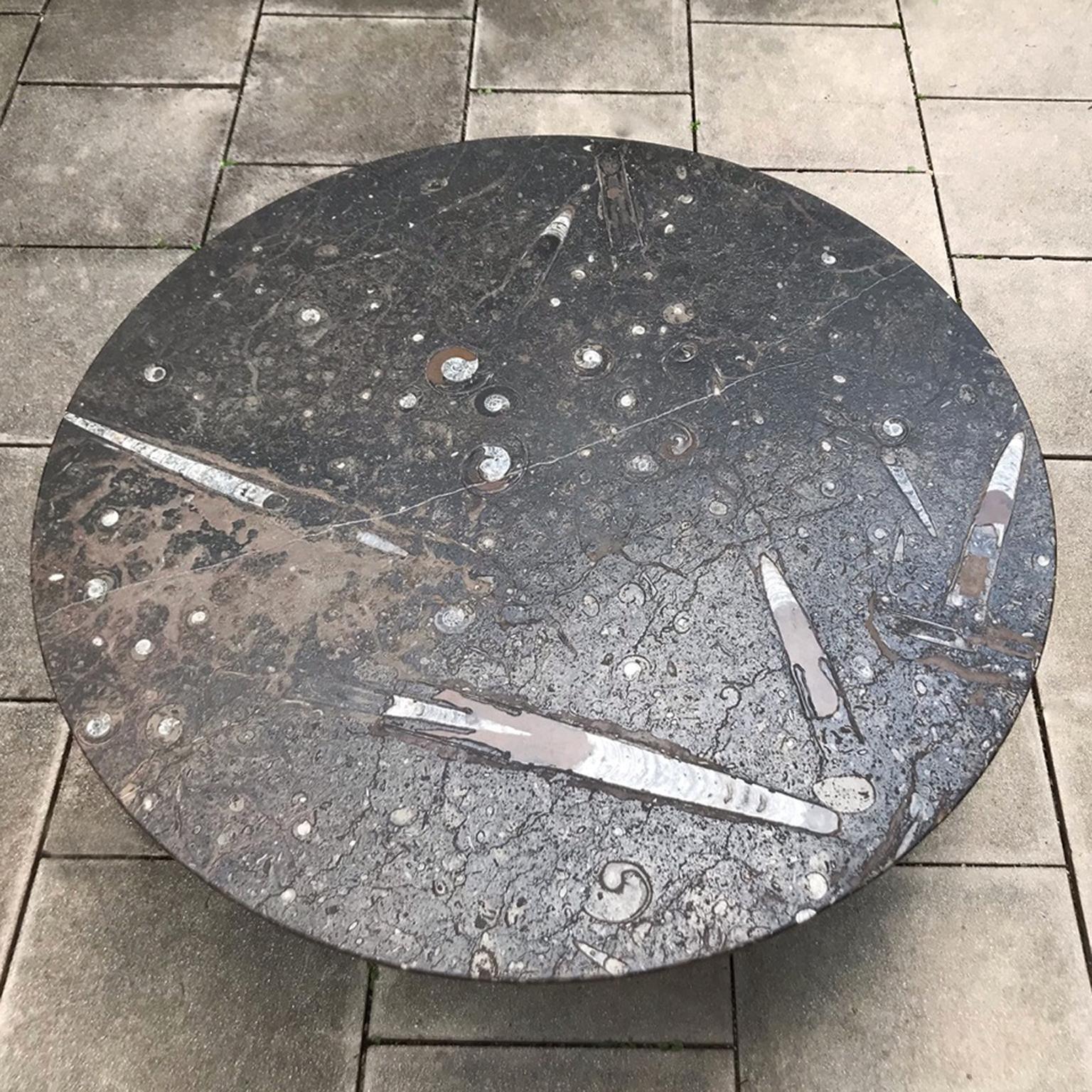 Le célèbre artiste allemand Heinz Lilienthal a conçu cette table basse accrocheuse en 1970. La caractéristique unique de cette table est le grand plateau rond en pierre avec des incrustations d'ammonites et de fossiles. Cela crée un aspect unique