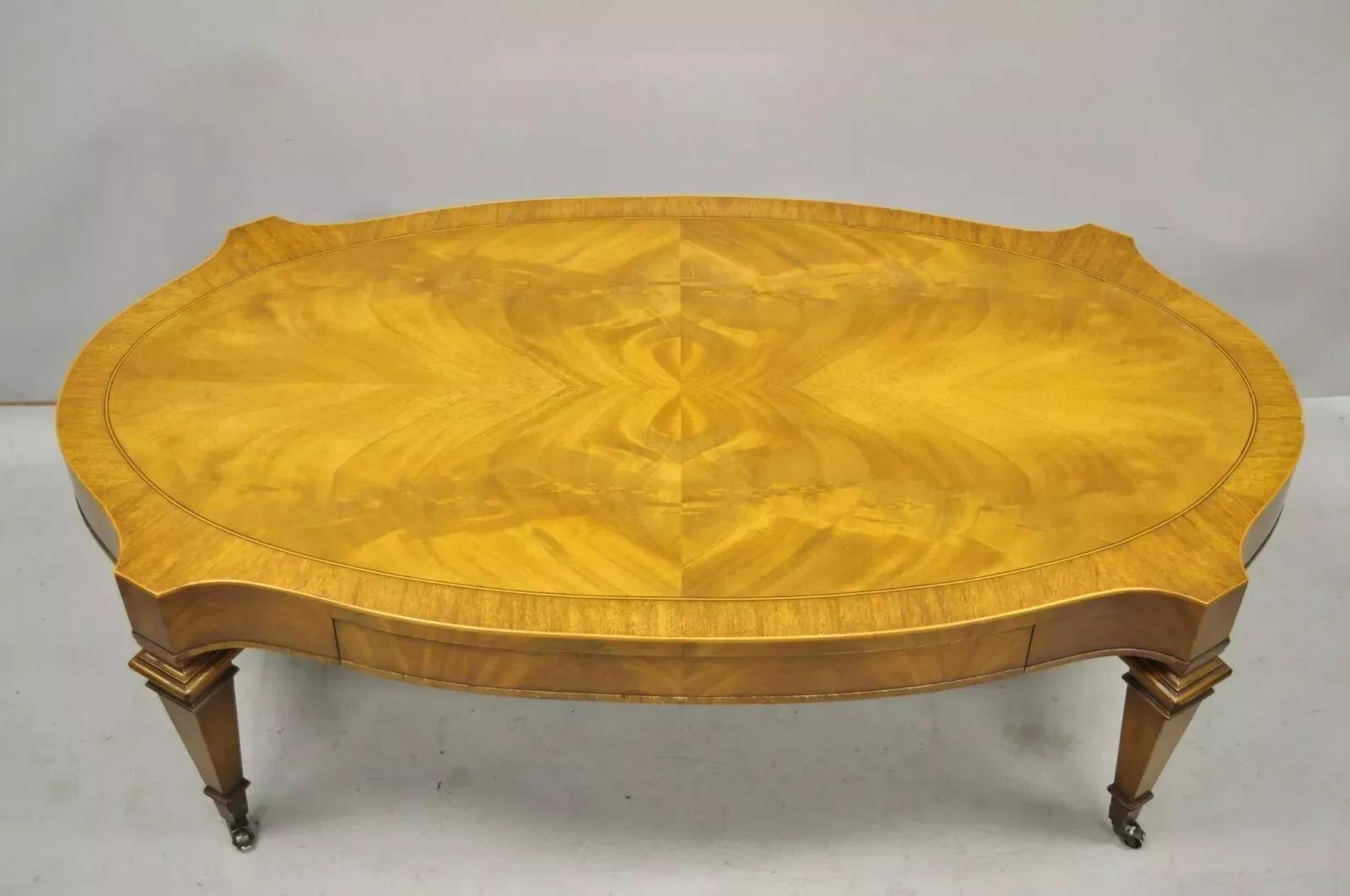 Heirloom Weiman Regency Style Flamed Mahogany One Drawer Coffee Table on Casters. Item features a custom glass top, brass rolling casters, inlay and banded top, finished back, 1 drawer, tapered legs, solid brass hardware, quality American