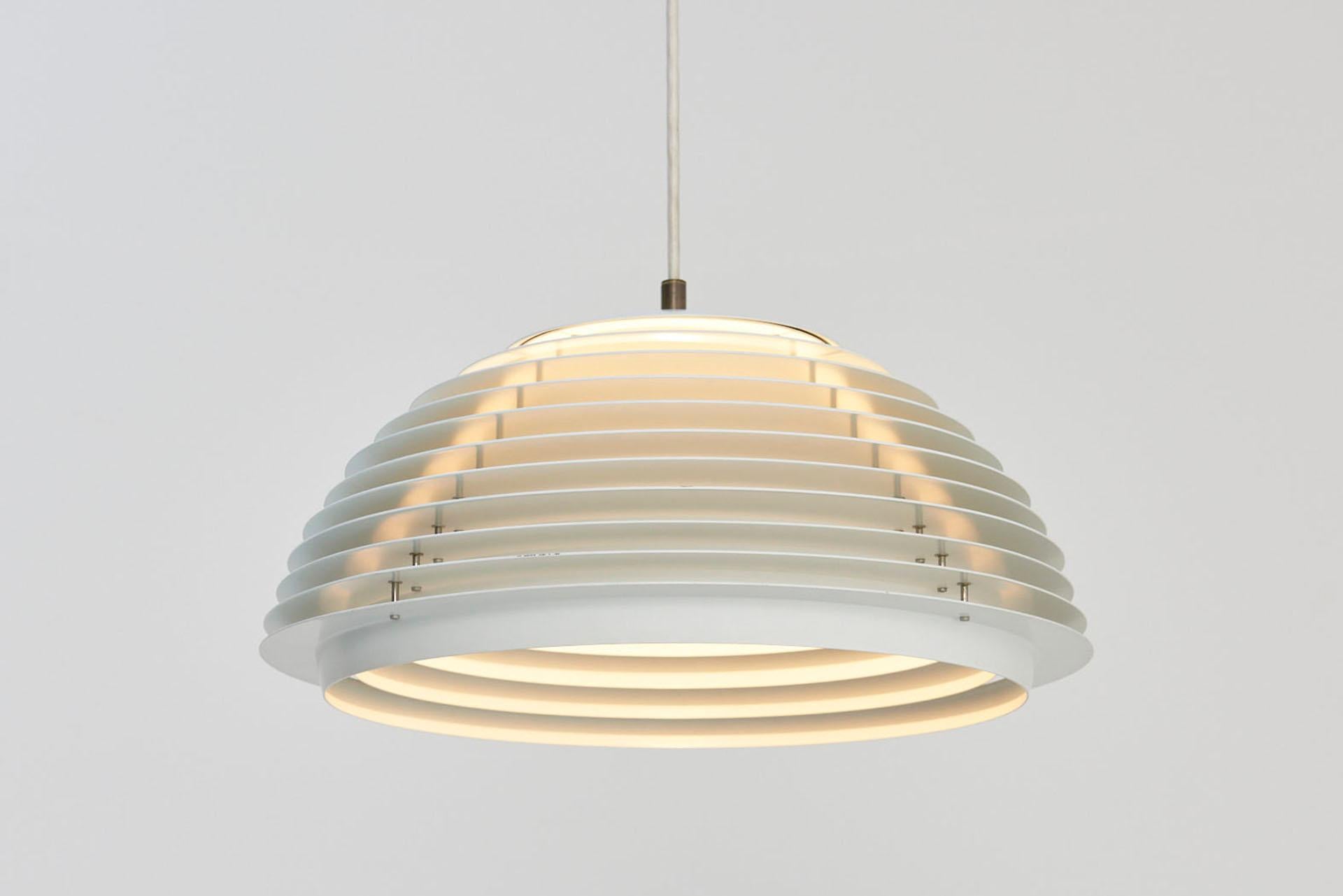 This Hekla pendant light was designed by Jon Olafsson & Pétur B. Luthersson and manufactured by Fog & Mørup in the 1960s. The white-lacquered metal rings are connected by small aluminium tubes and they produce a pyramid-shaped light beam. The lamp