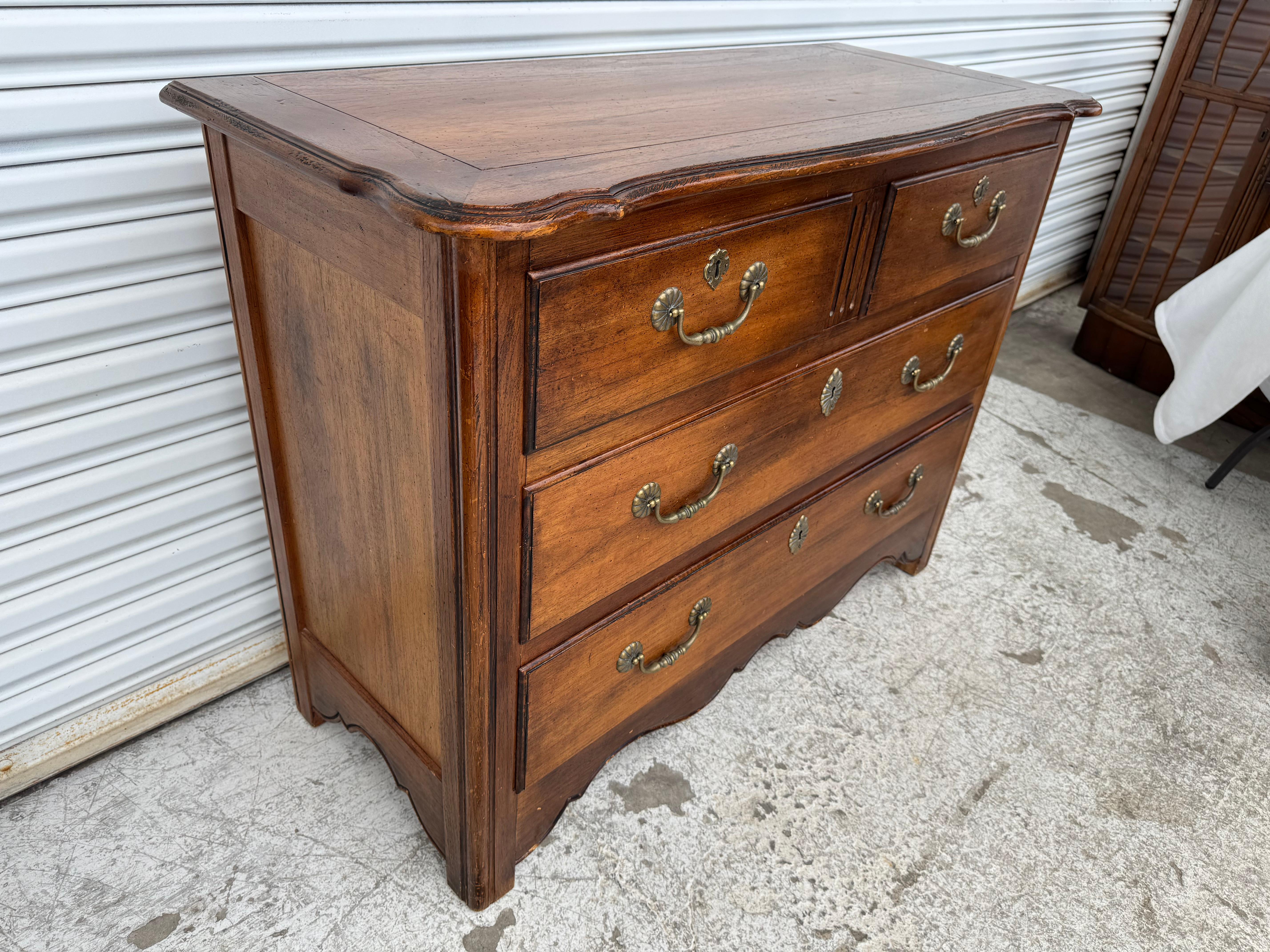 This vintage Hekman chest of drawers showcases classic craftsmanship and timeless design, featuring a warm, rich wood finish with a gently aged patina that highlights the natural grain. The piece is constructed with four spacious drawers—two smaller