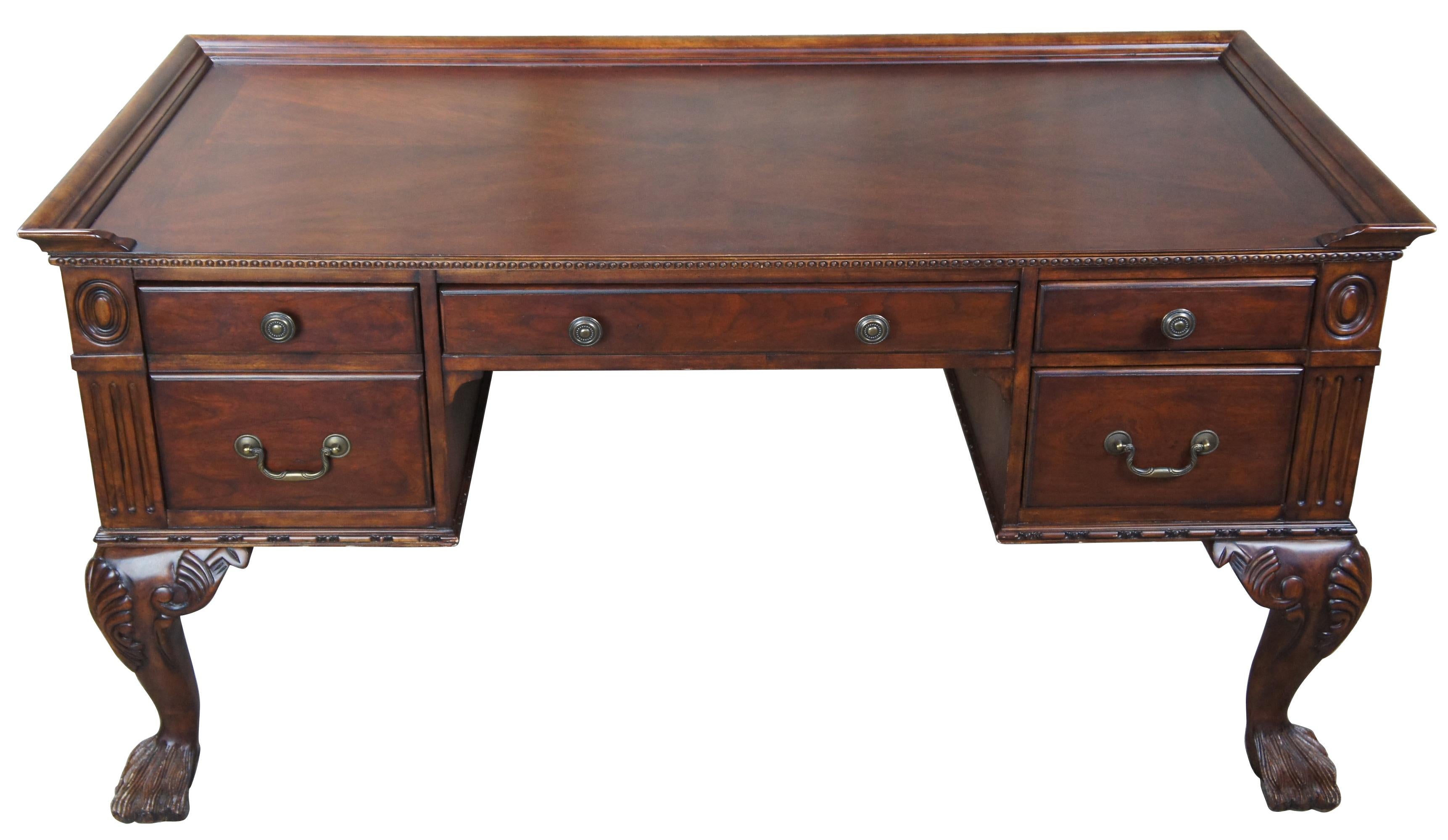 Hekman Furniture mahogany writing desk. Features Chippendale styling with hairy paw feet. Includes four drawers, scalloped legs, gadrooning and fluting along the trim, and a gallery around the surface. Additionaly features, a matchbook veneer top