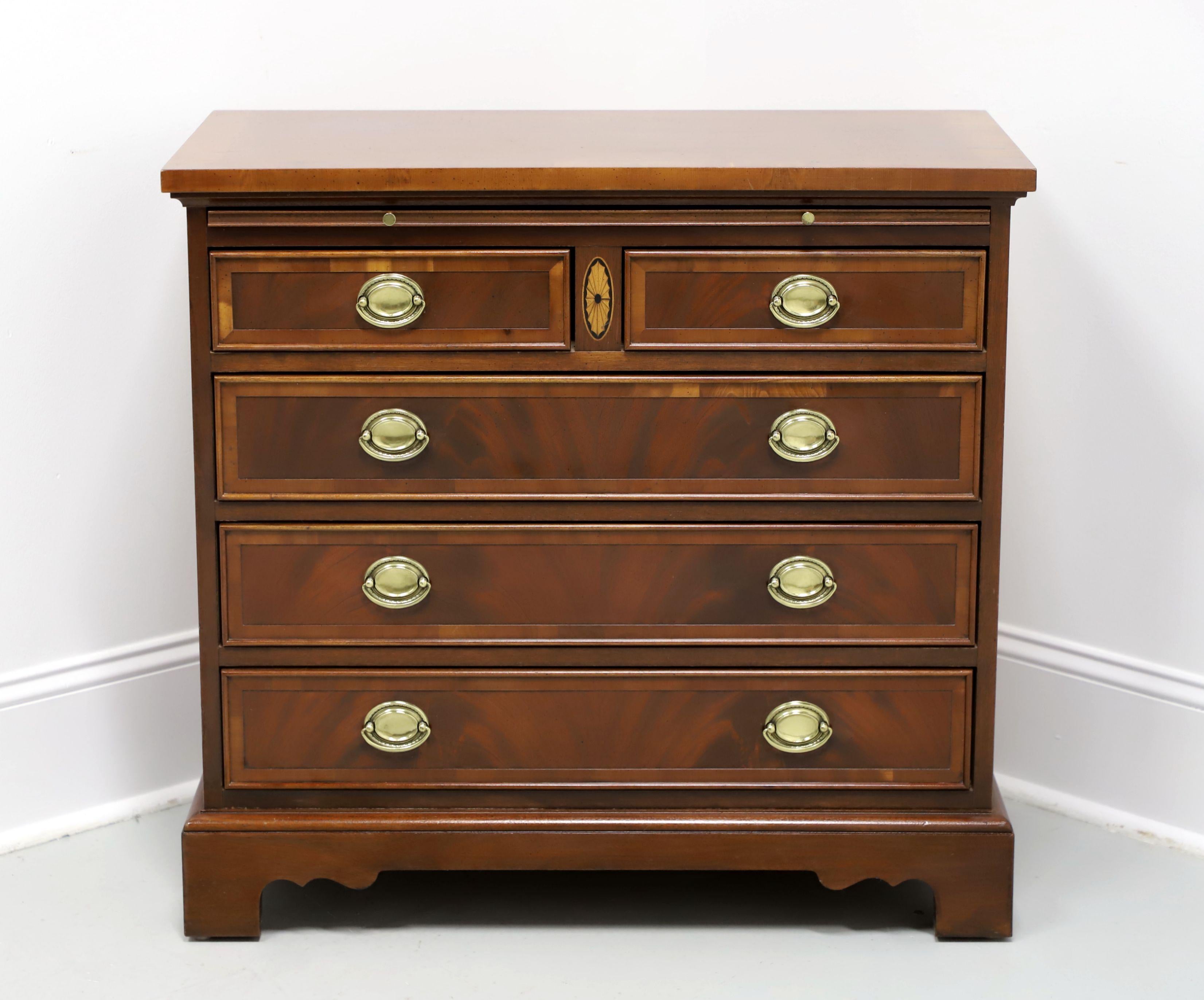 A Georgian style bachelor chest made by Hekman, from their Copley Place Collection. Mahogany with inlaid ebony wood & generous applications of yew wood, brass hardware, banded top with miter edge, brushing slide, banded drawer fronts, and bracket