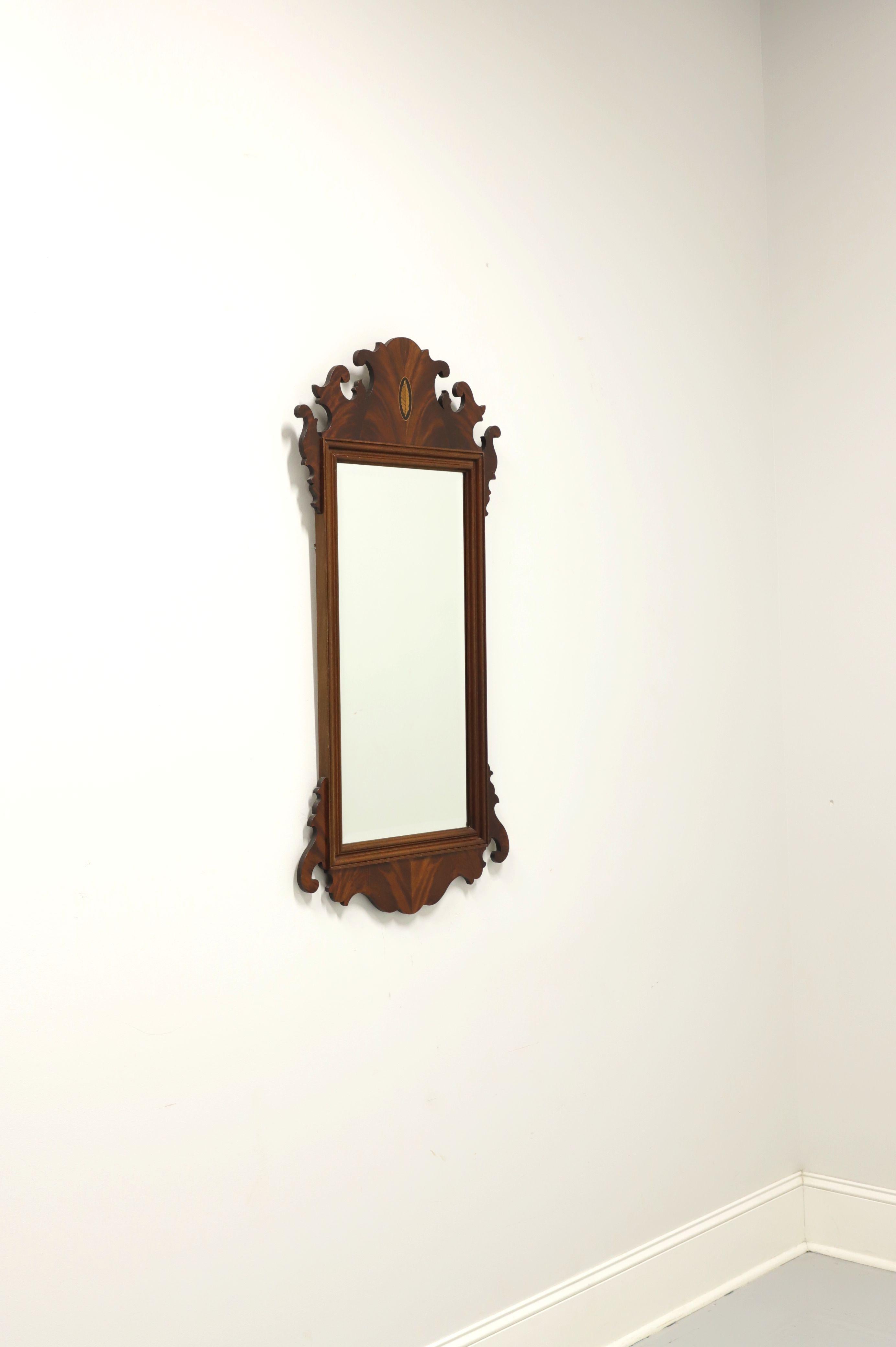 A Chippendale style wall mirror by Hekman. Bevel edge mirrored glass in a decoratively carved crotch mahogany frame with inlaid medallion to top center. Made in the USA, in the late 20th Century. 

Style #: 5-158

Measures: 22W 1.25D 42.75H, Weighs