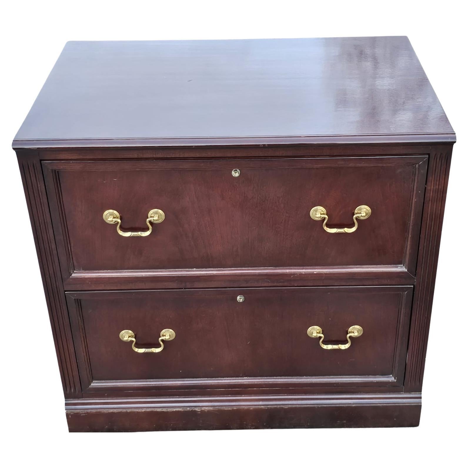 A two drawer lateral two-Drawer cherry Executive filing cabinet. Two deep drawers independently locking. Glossy varnish finish. Measures 32