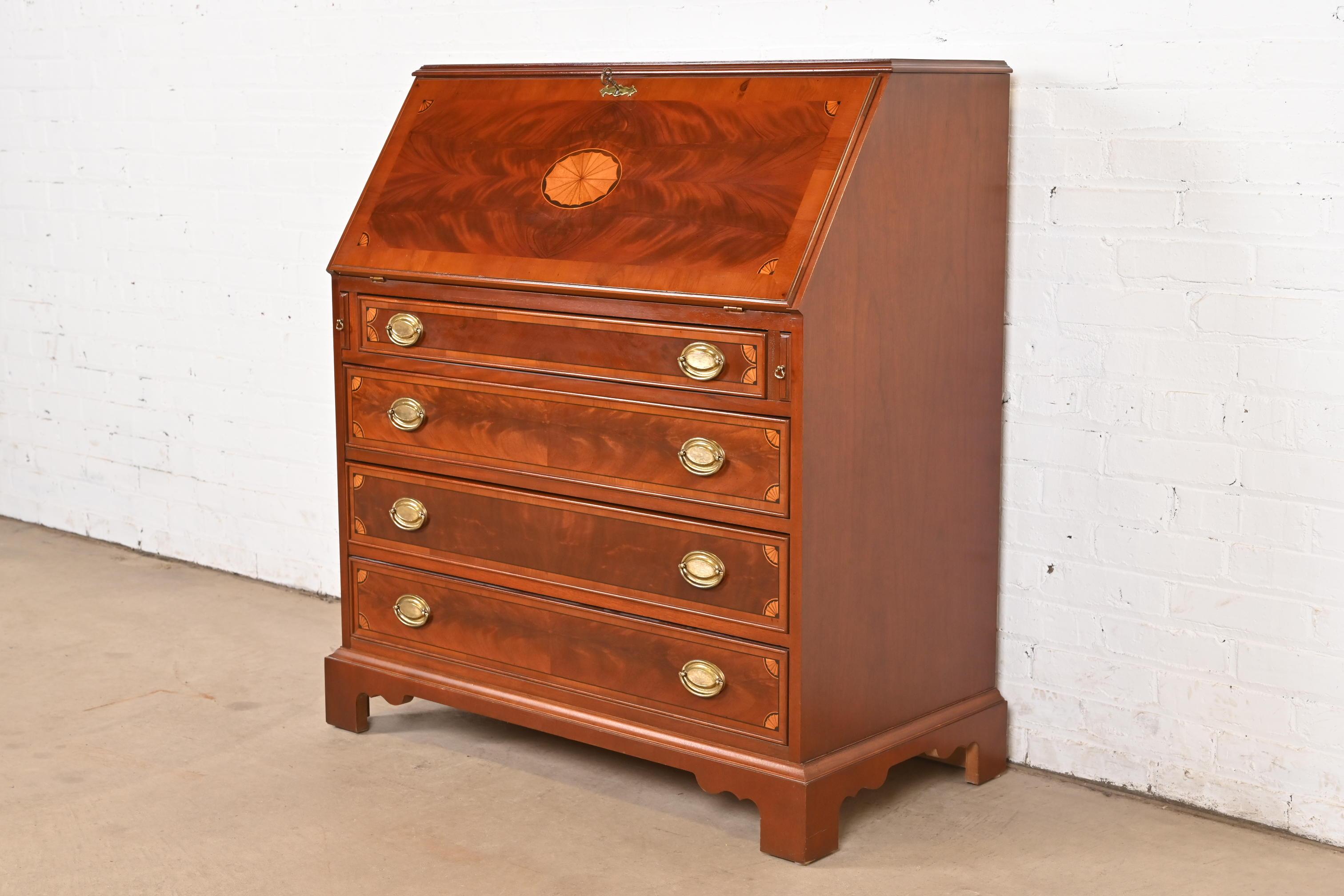 Magnifique bureau ou secrétaire de style Feder ou Hepplewhite à façade inclinée.

À la manière des meubles Baker

Par Hekman Furniture

USA, Circa Late 20th Century

Magnifique acajou flammé, avec marqueterie de bois satiné et quincaillerie en