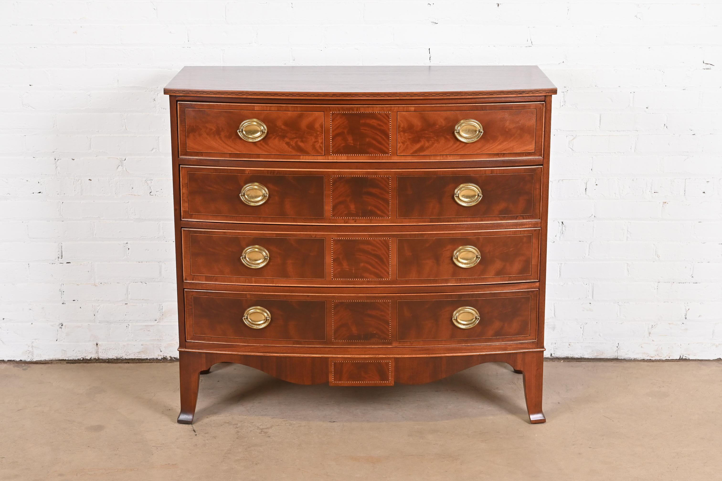 A gorgeous Georgian style bow front four-drawer commode, dresser, or chest of drawers

By Hekman Furniture

USA, Circa 1980s

Beautiful flame mahogany, with satinwood and ebony inlay, and original brass hardware.

Measures: 42