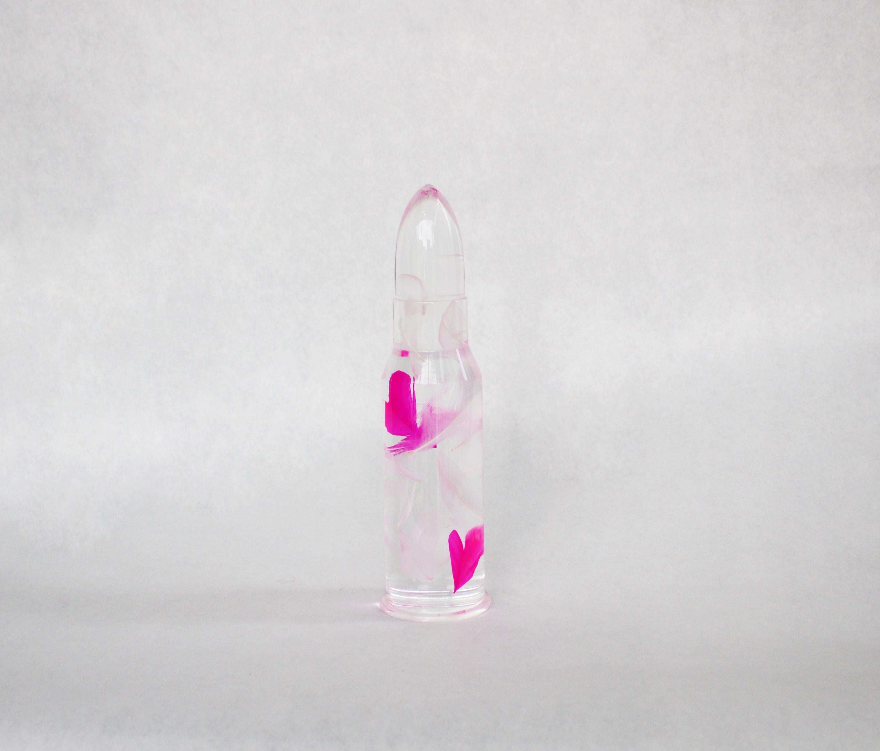 Faux white and hot pink feathers suspended in Resin bullet form.

About the Artist
Helder Batista is a self-taught artist who works predominantly in sculpture medium. Born in 1964 in Paris and now living and working near Cahors, he describes the