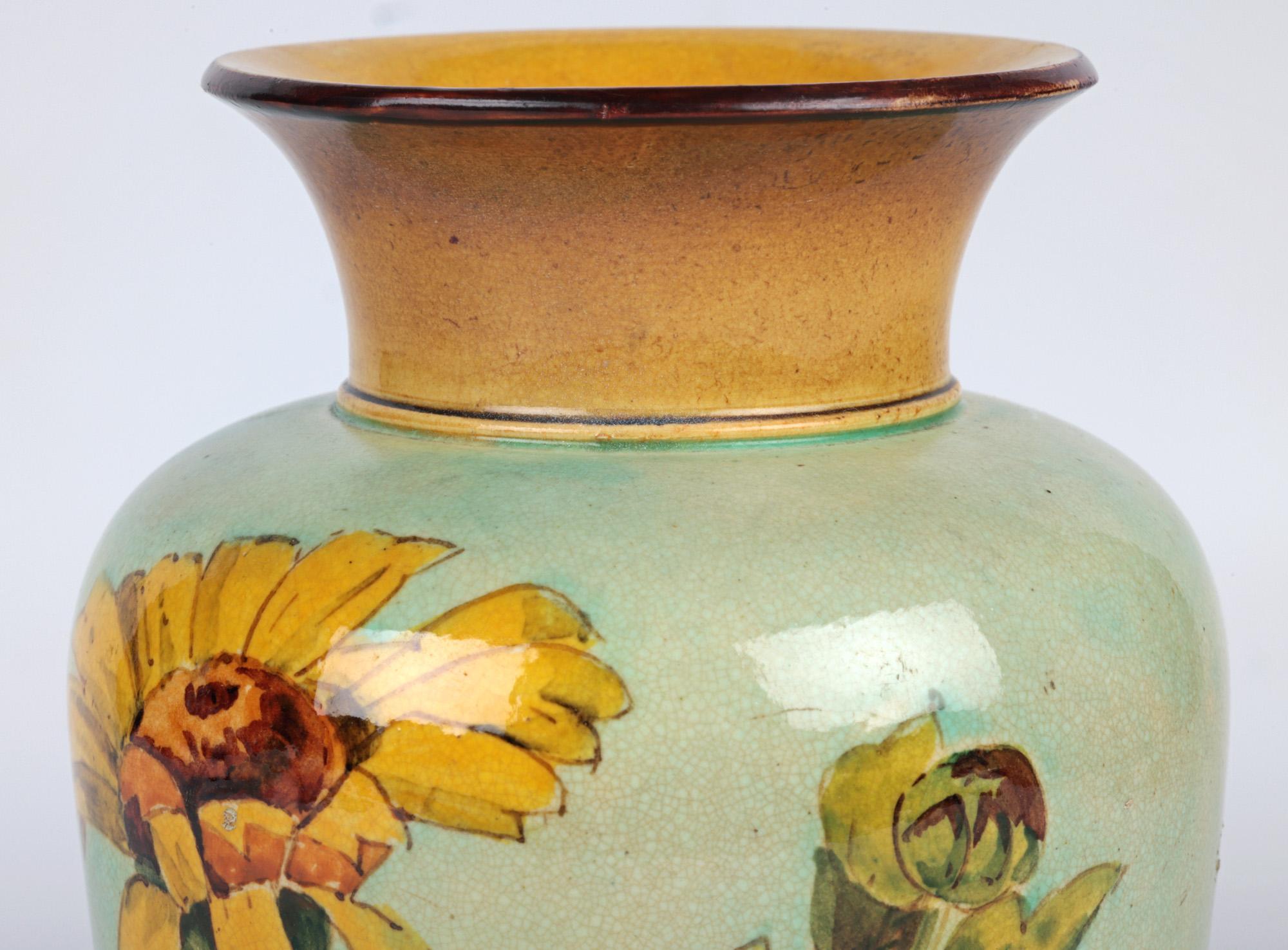 A stylish and decorative Doulton Lambeth Faience floral painted art pottery vase by renowned flower painter Helen A Arding and dating between 1877 and 1884. The stoneware vase stands on wide rounded pedestal foot with a tapering bulbous shaped body