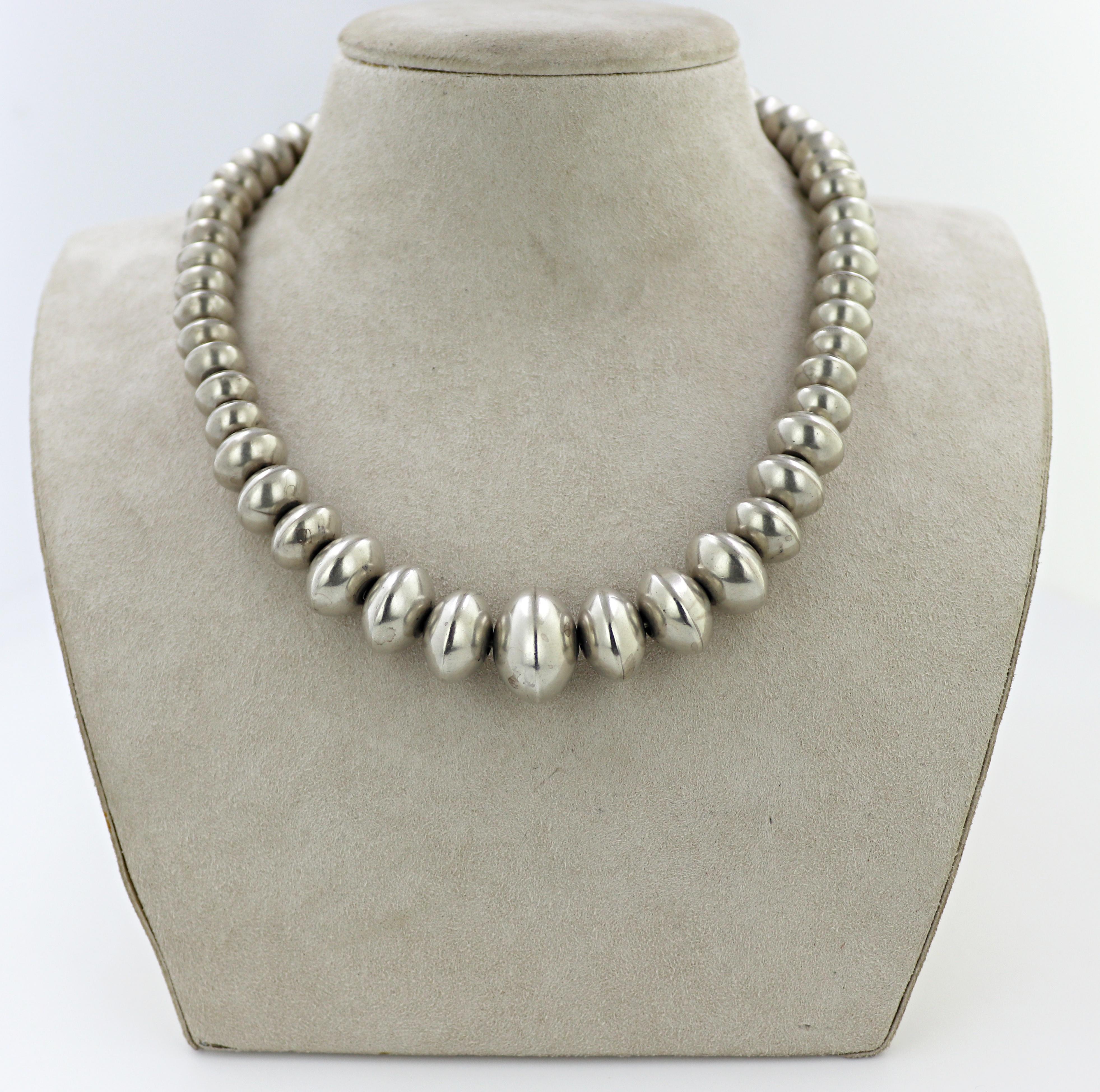This beautifully aged necklace is composed of (51), handmade, sterling silver graduating saucer beads,
18.6 to 10.3 mm, completed by a wire hook and loop clasp, forming a 17 inch necklace, marked Helen
Chee, sterling, Gross weight 99.99