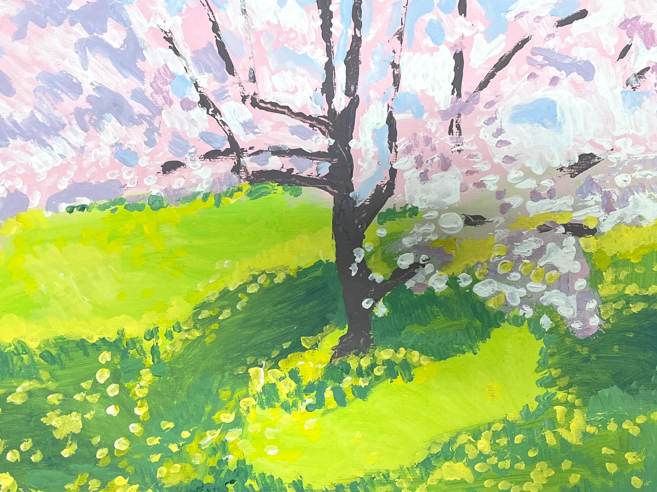 Un albero di ciliegio in fiore getta i suoi petali su un prato verde baciato dal sole