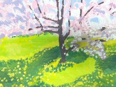 A Blooming Cherry Blossom Tree Casts Its Petals Over a Sun-Kissed Green Meadow