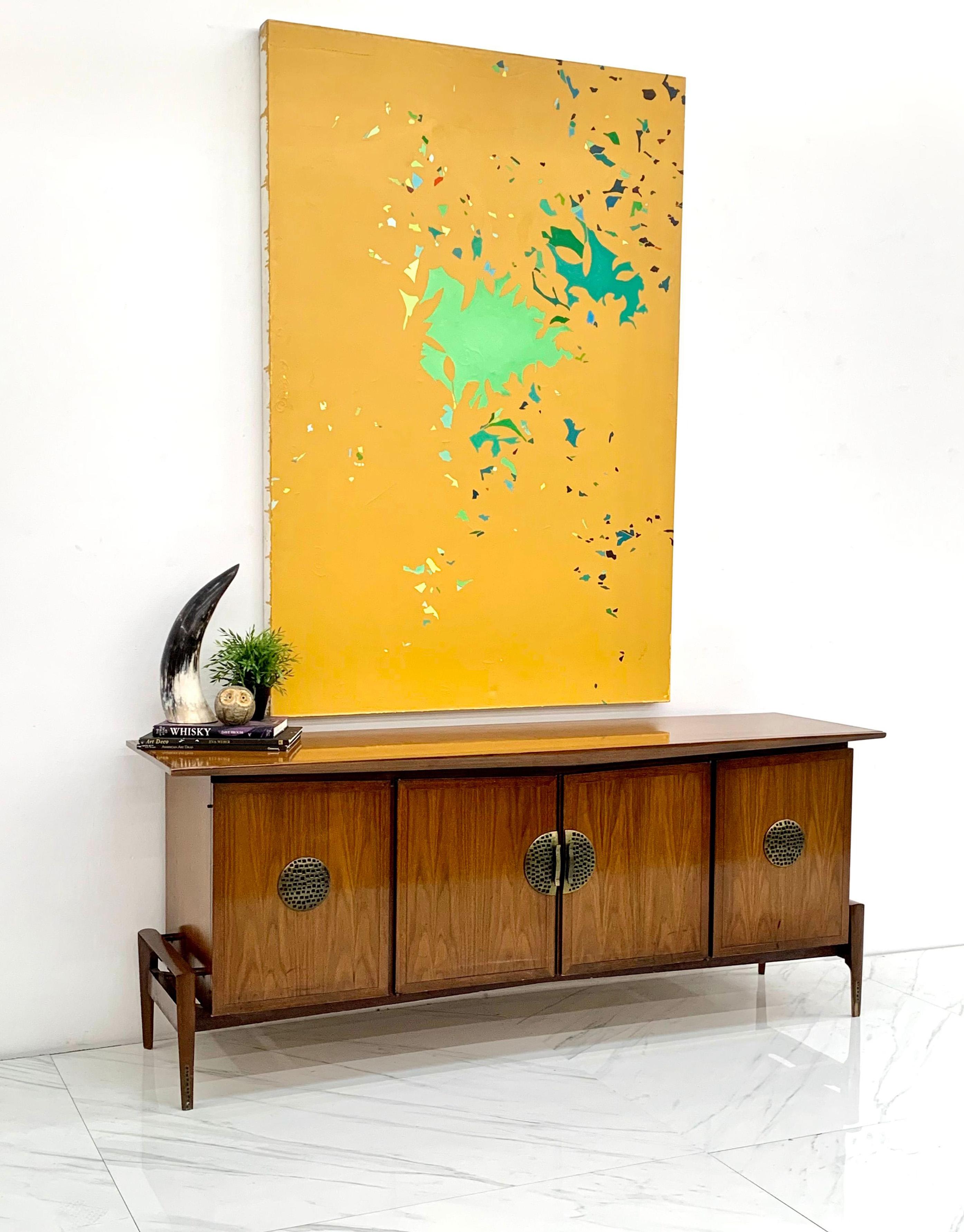 This gorgeous walnut credenza was designed by Helen & Hobey Baker in the 1950's. This piece has all the fun aspects of a true bold mid century modern piece -- clean, angular swooping lines that give the piece an almost googie look that is