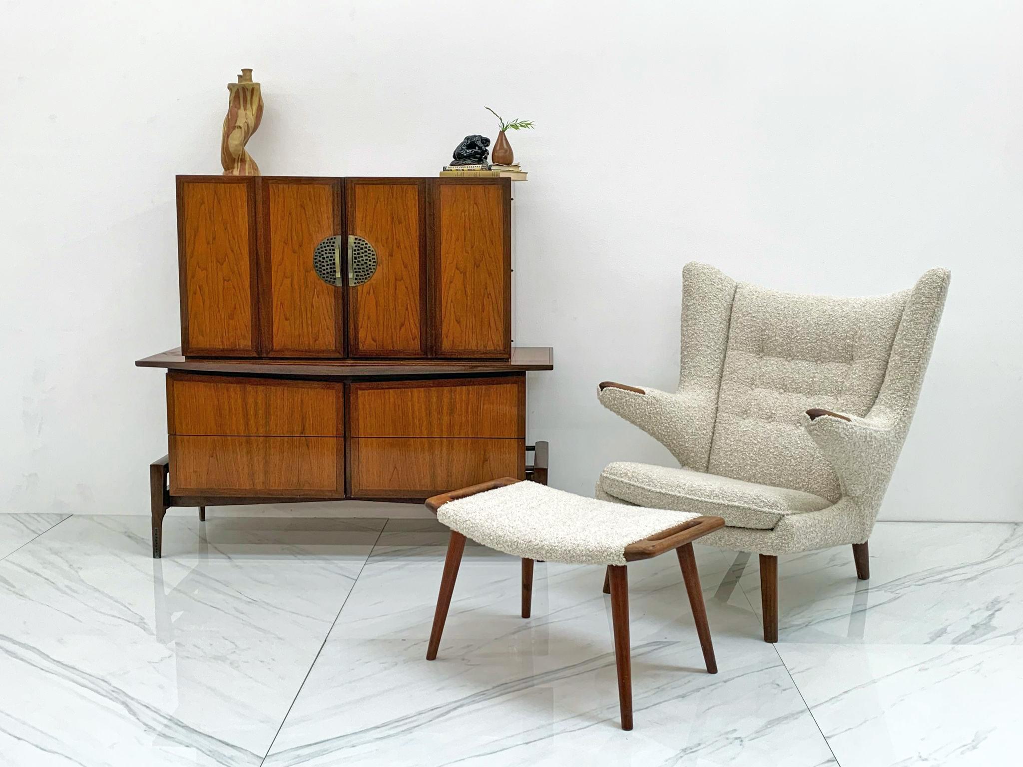 This gorgeous walnut 2 piece chest on chest was designed by Helen & Hobey Baker in the 1950's. This piece has all the fun aspects of a true bold mid century modern piece -- clean, angular swooping lines that give the piece an almost googie look that