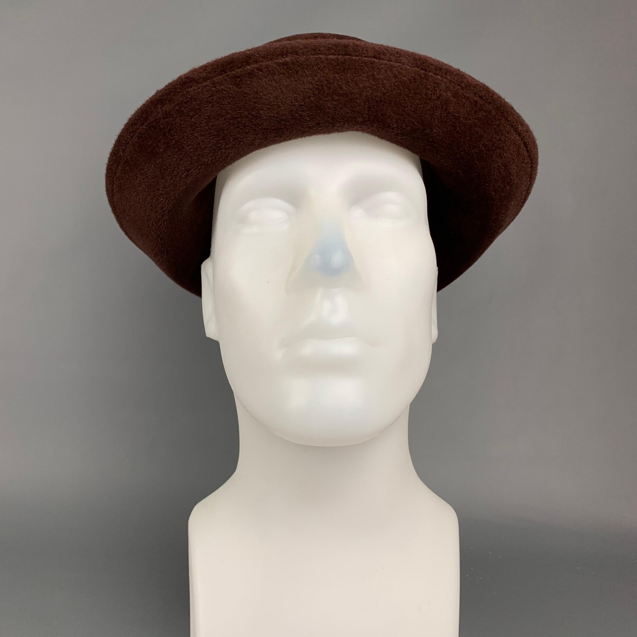 HELEN KAMINSKI hat comes in a brown felt material featuring a round shape and a black elastic strap detail. Includes box. 

Very Good Pre-Owned Condition.
Marked: M

Measurements:

Opening: 25 in.
Brim: 2 in.
Height: 2.5 in. 
