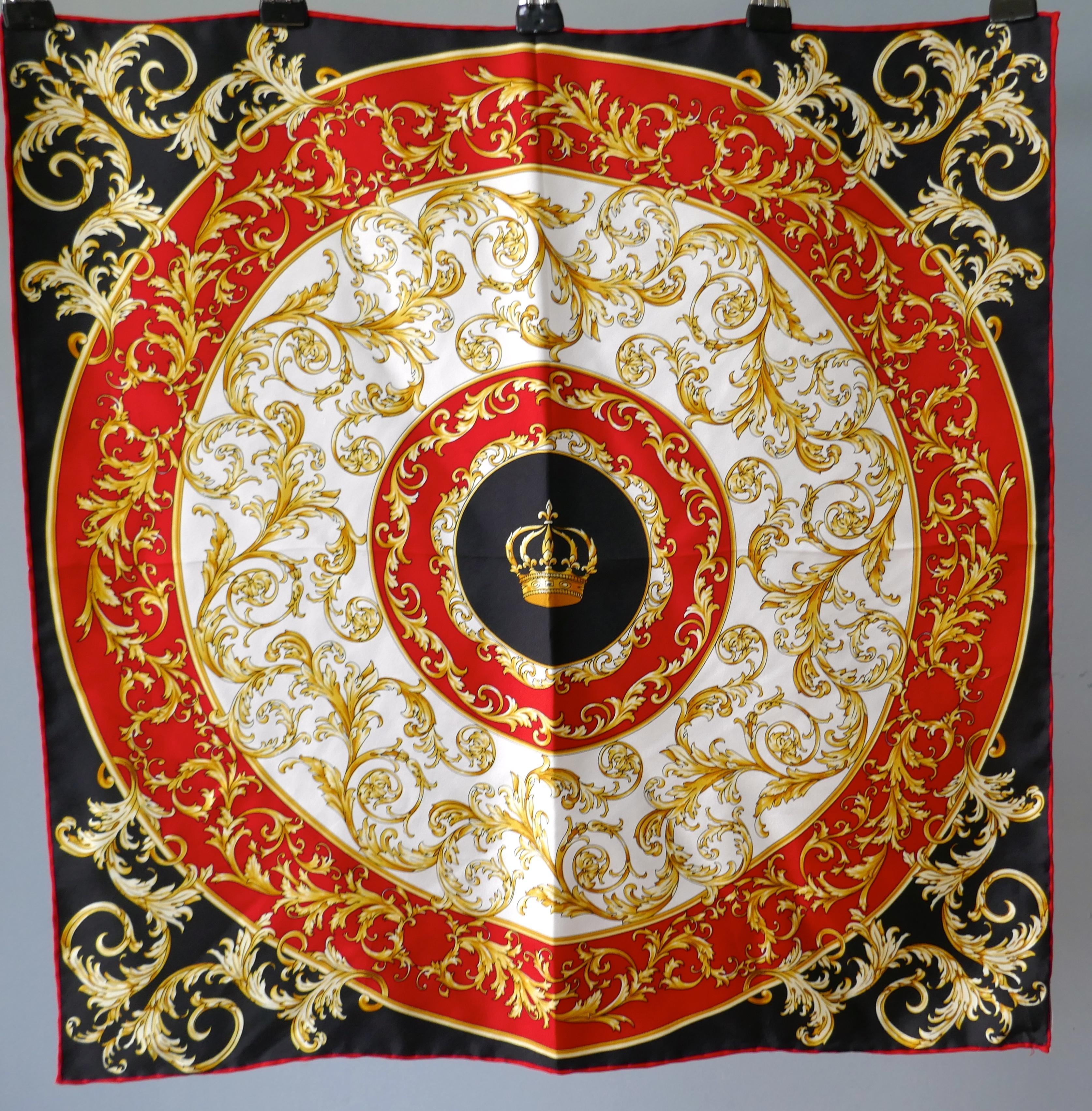 Helen Leigh Silk Neck Scarf Classical Armorial Design from the Italian Collection

Lovely scarf with Crown set in a central cartouche, this denotes a Titled connection 
In Gold, Black and Red Pallet, Silk Scarf measures 21”x 21”
It is as crisp as