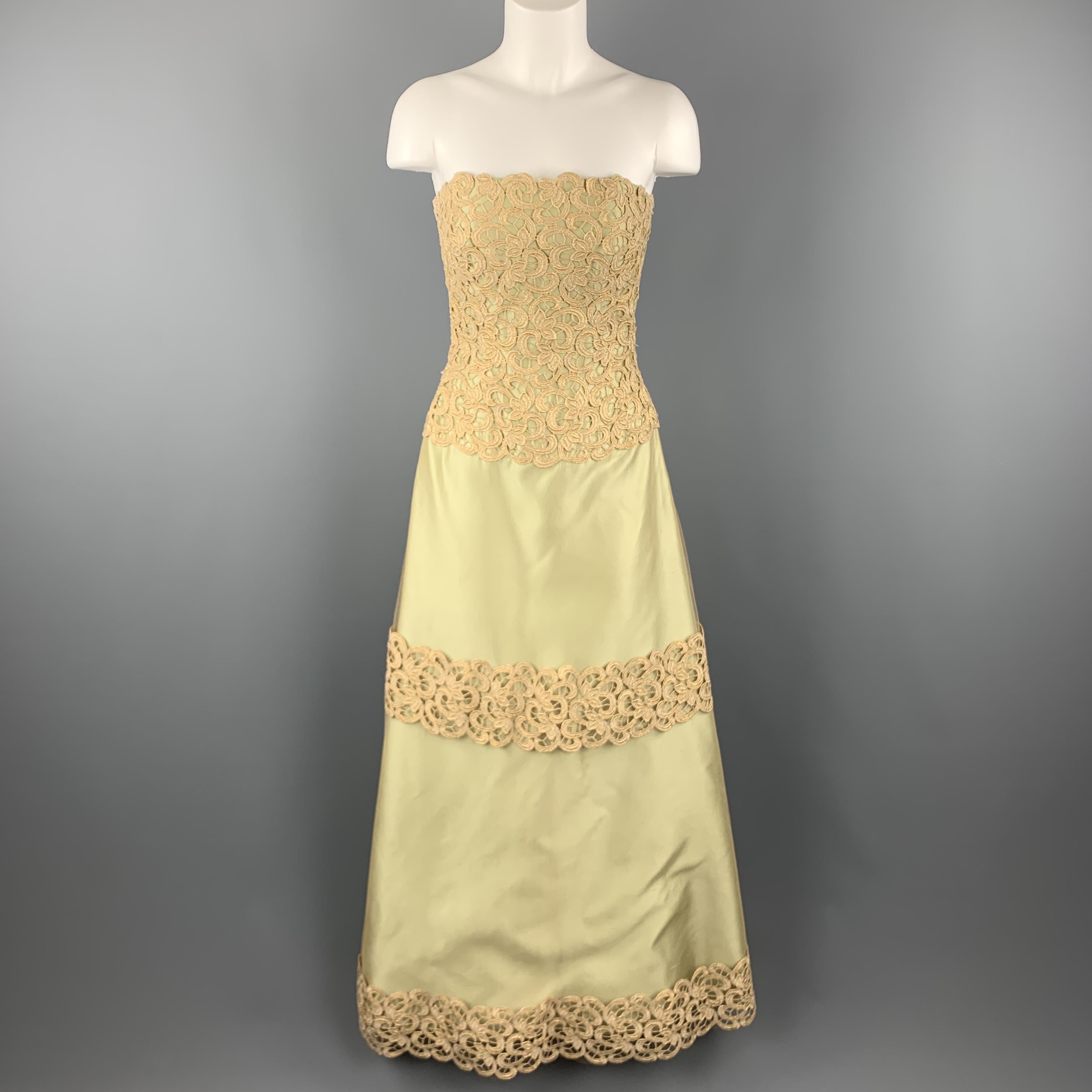 HELEN MORLEY evening gown comes in light green silk taffeta with a metallic gold tulle overlay and features a metallic lace overlay, strapless bustier bodice and full side pleat A line skirt with lace stripe appliques. Includes a matching shoulder