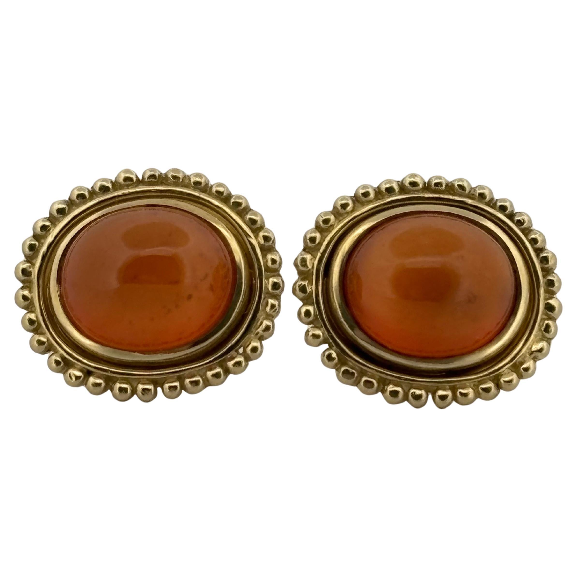 These elegant Helen Woodhull clip-on earrings embody timeless sophistication and exceptional craftsmanship. Meticulously crafted in 18k yellow gold, they feature two luminous oval cabochon citrines with a combined total weight of 16 carats. The