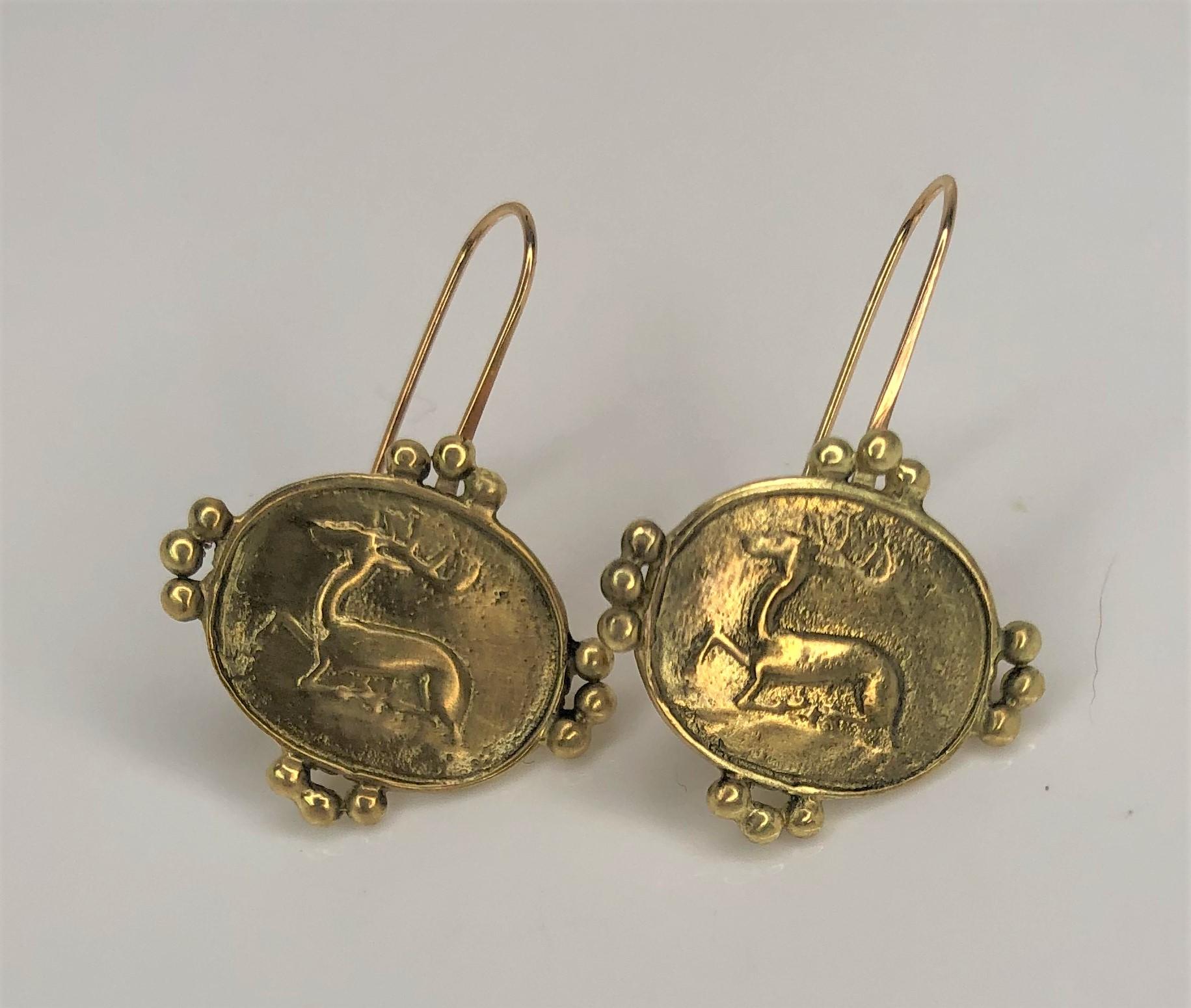 Diese Tropfenohrringe der Designerin Helen Woodhull werden Ihr neues Lieblingsstück sein!
18 Karat Gelbgold mit ovalem Draht. 
Jeder ovale Tropfen ist mit der Intaglio eines Hirsches verziert und mit vier goldenen Dreiergruppen geschmückt.