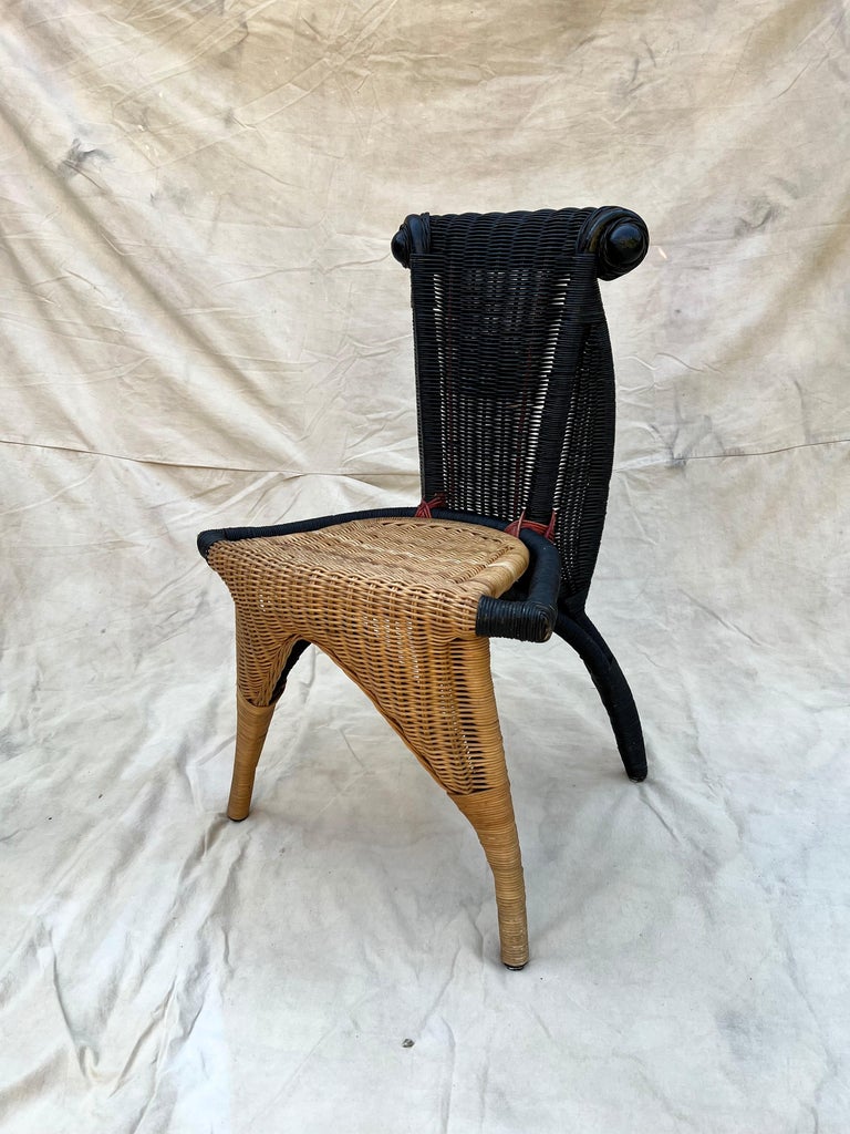 Unique wicker chair woven from black plastic and natural material. 

The Helena chairs have a back made of black plastic wickerwork that ends at the top in a kind of ram's Horn. This combined with the rattan The use of animal and organic forms