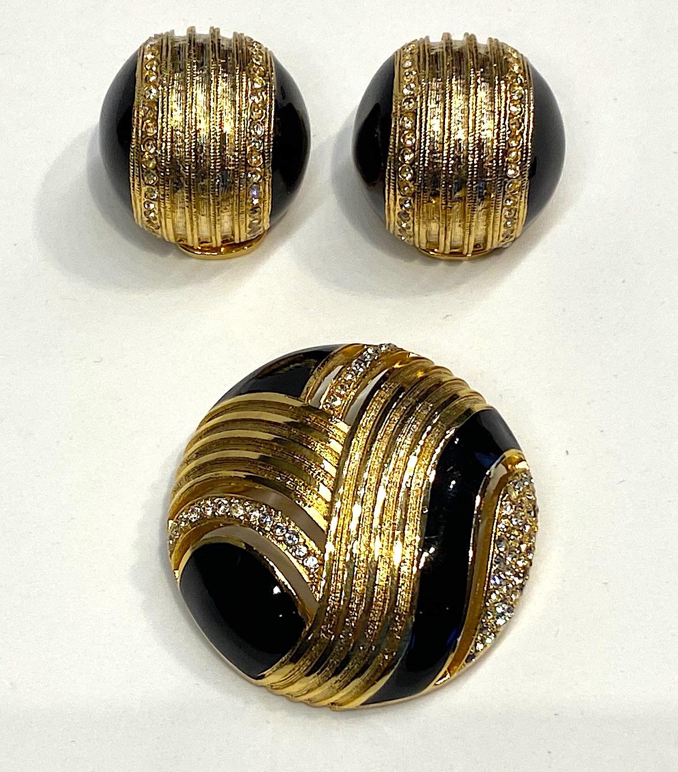 Broche et boucles d'oreilles Helena Rubinstein, style Art déco des années 1980, avec dôme en or. La broche en forme de dôme présente des bandes découpées qui suivent le motif de la bande dorée, de l'émail noir et des accents en strass. Il mesure