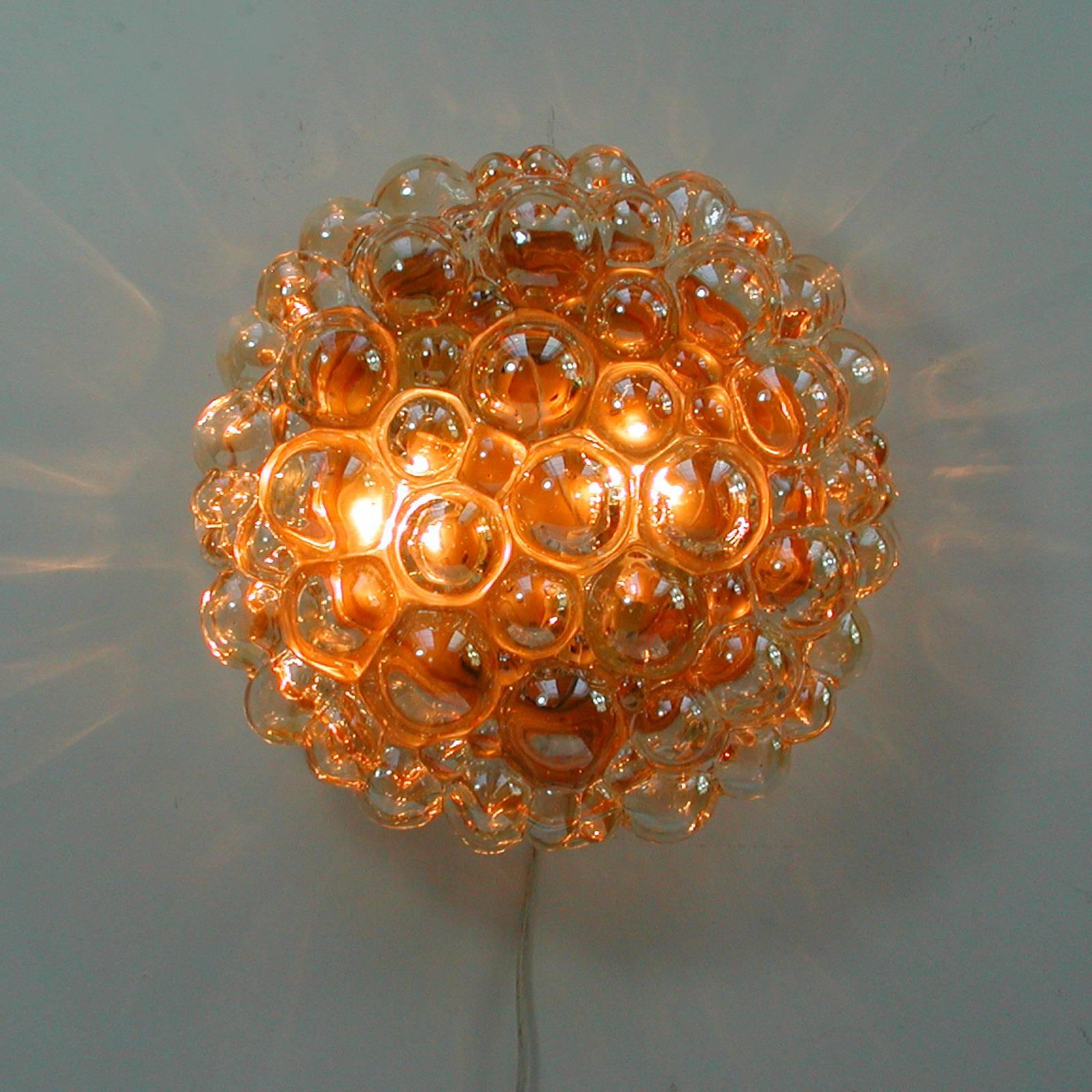 Beautiful large bubble sconce or wall light or flush mount by Helena Tynell for Glashütte Limburg, Germany, 1960s.
Made of glossy amber colored glass with a gilt colored base.