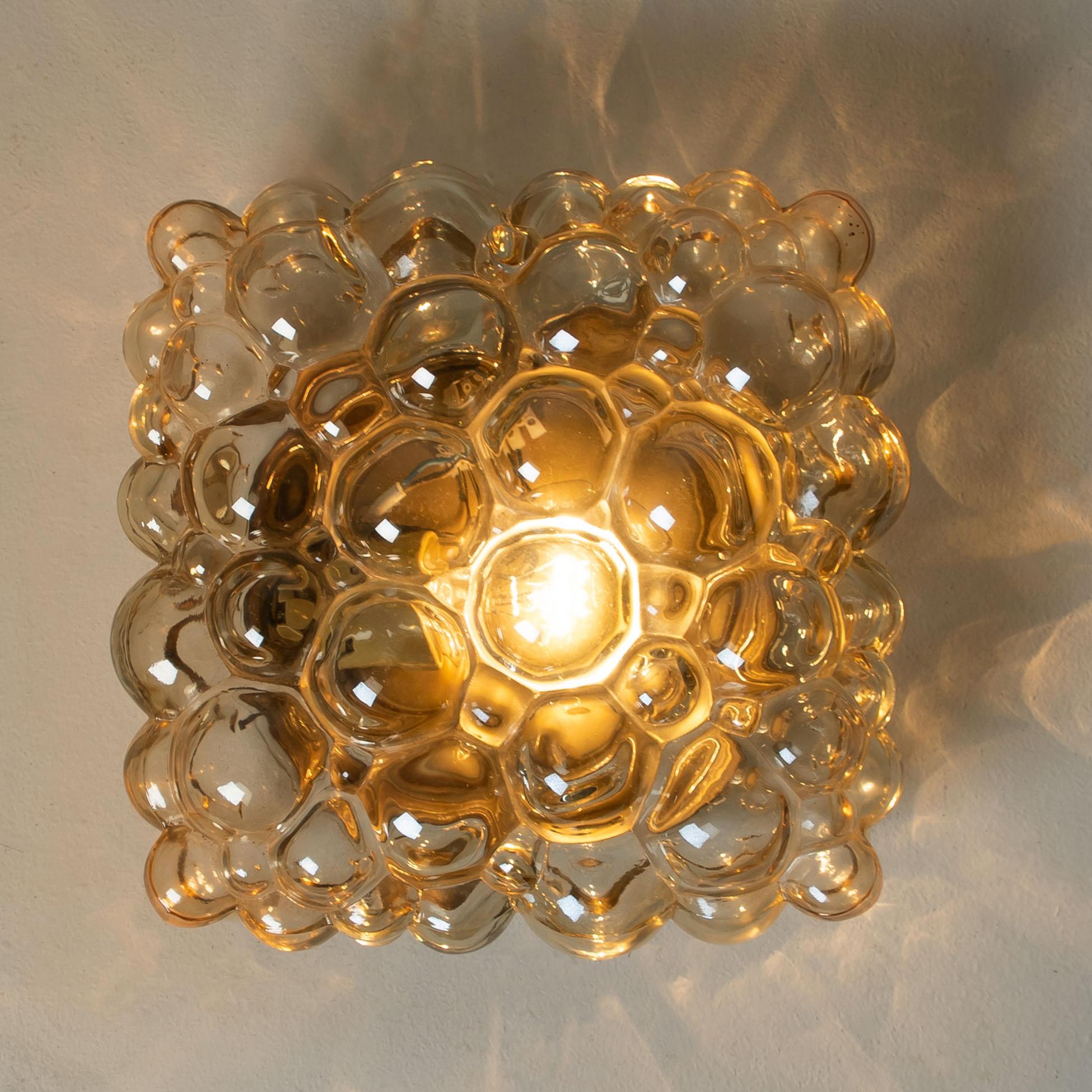 Beautiful high-end large bubble wall lights or flush mounts by Helena Tynell for Glashütte Limburg, Germany, 1960s. 
A design Classic, made of glossy amber bubble glass.
 
The price is for a pair. They will be sold individually or as pair. Can