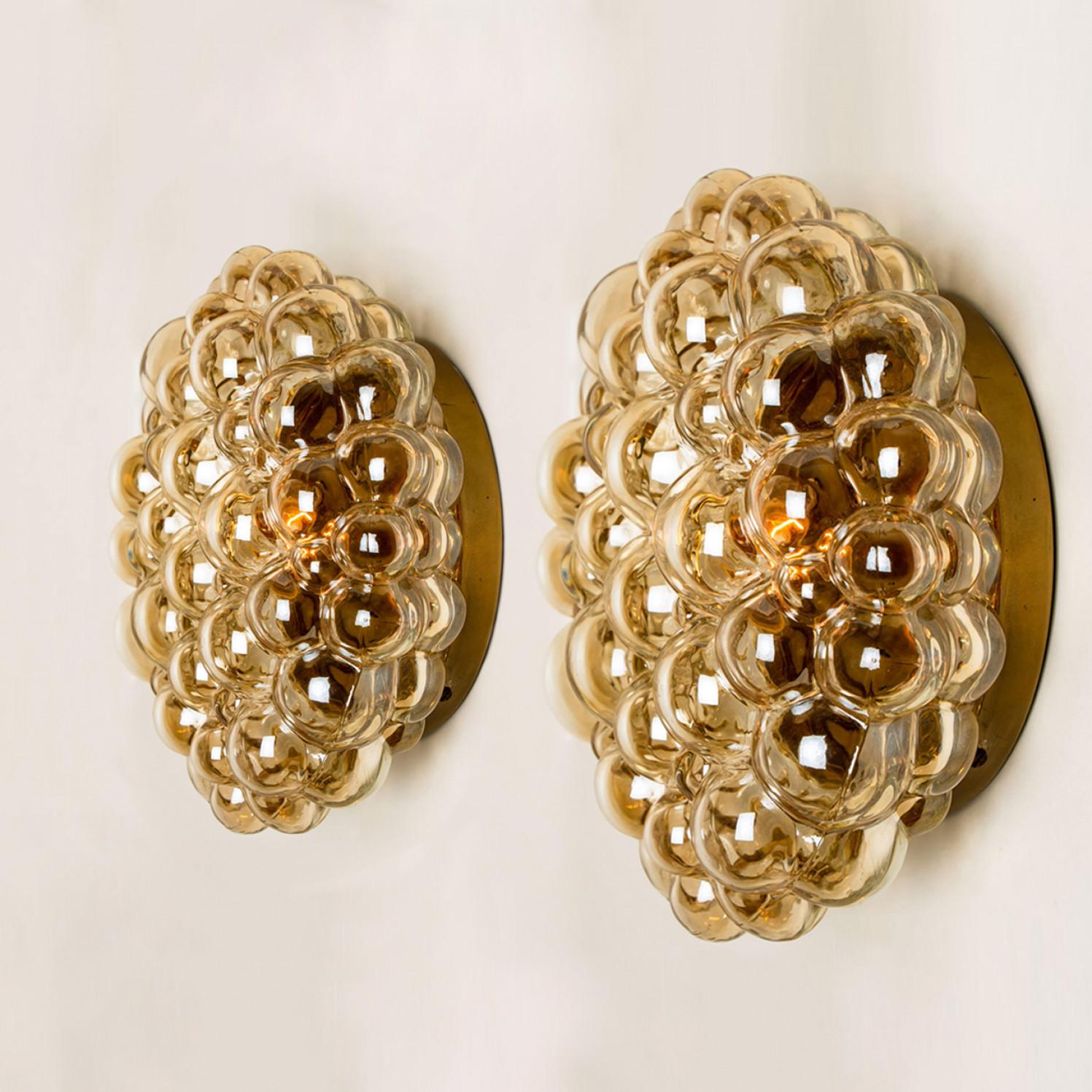 Beautiful bubble glass wall lights designed by Helena Tynell for Glashütte Limburg. A design Classic, the amber toned of the hand blown glass gives a wonderful and warm glow.

Heavy quality and in excellent vintage condition. Cleaned, well-wired and
