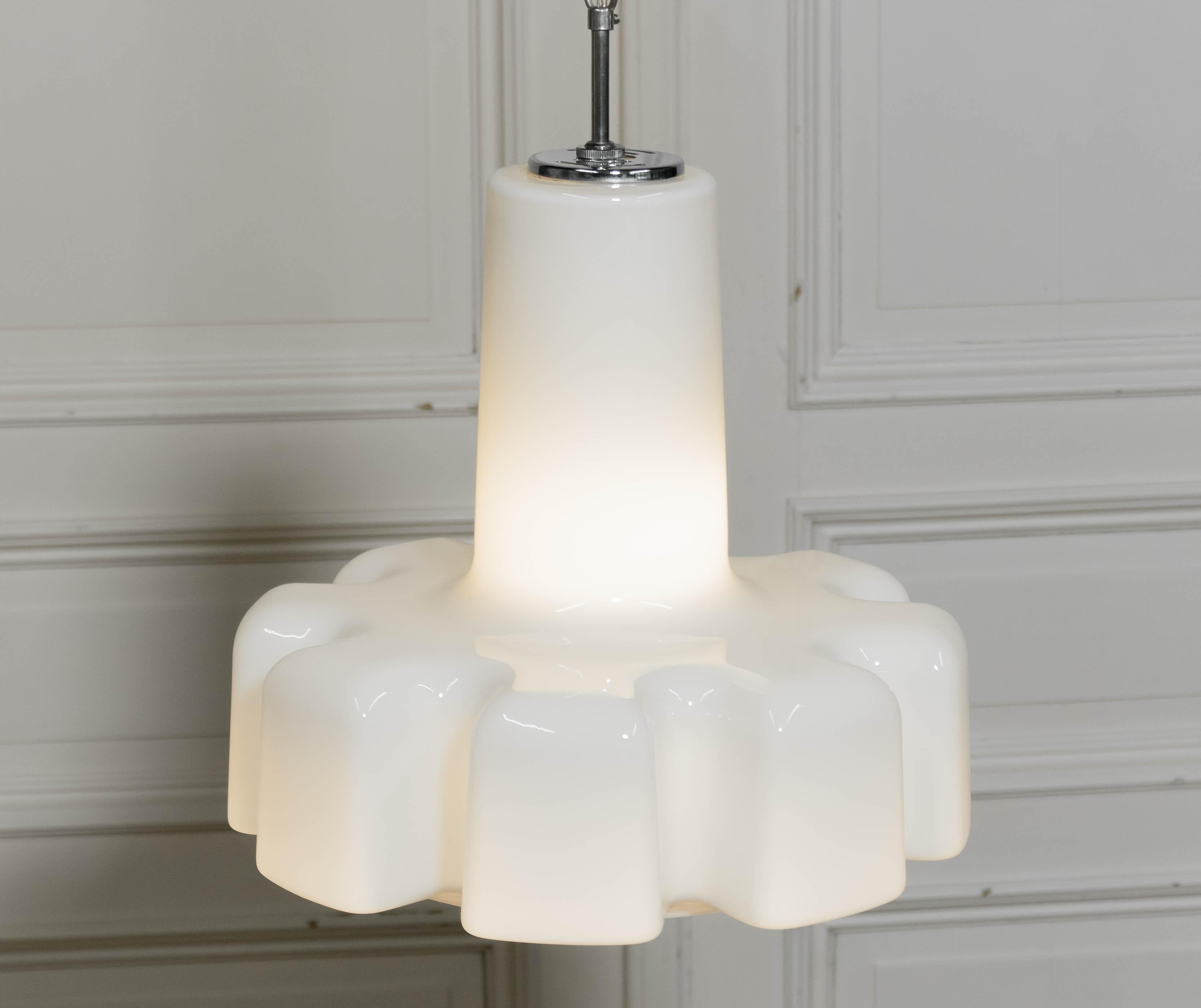 Elegante lampada a sospensione disegnata da Helena Tynell per Flygsfors, Svezia. Questo pezzo di metà secolo è realizzato in vetro opalino bianco di alta qualità e presenta una silhouette unica e scultorea con segmenti dolcemente arrotondati che