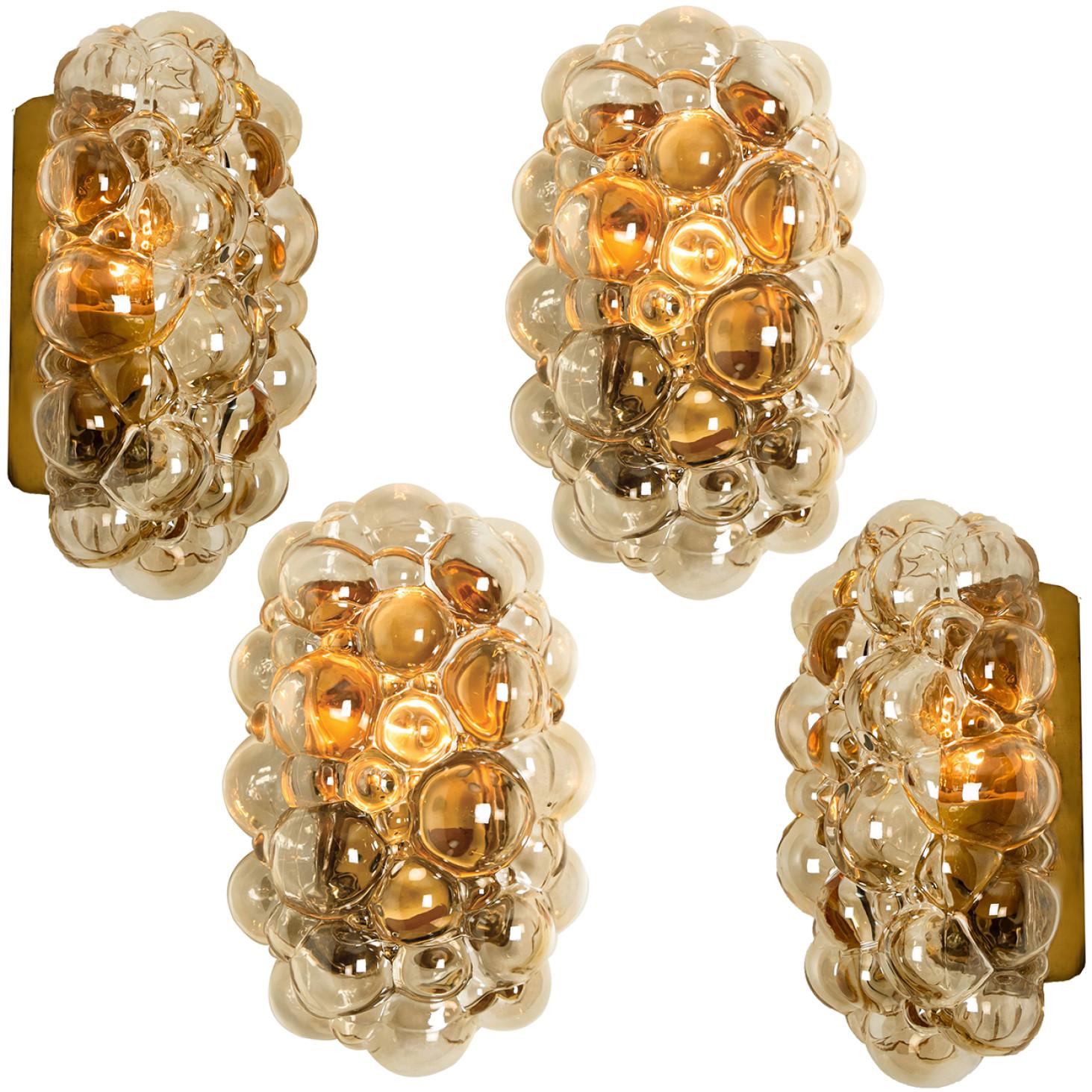 A pair beautiful high-end large bubble wall lights by Helena Tynell for Glashütte Limburg, Germany, 1960s.
Made of glossy amber colored glass with a brass colored base. Illuminates beautifully.

They will be sold as pair . Can work as impressive
