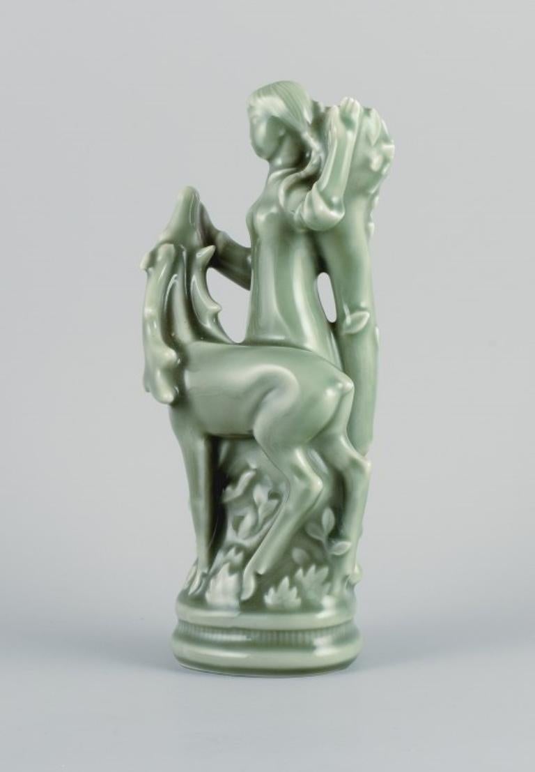 Helge Christoffersen (1925-1965) for Royal Copenhagen.
Art Deco sculpture in stoneware of a young woman with a deer.
Celadon glaze.
Marked.
First factory quality.
Model number 4350.
In good condition with small chip on antler.
Dimensions: H