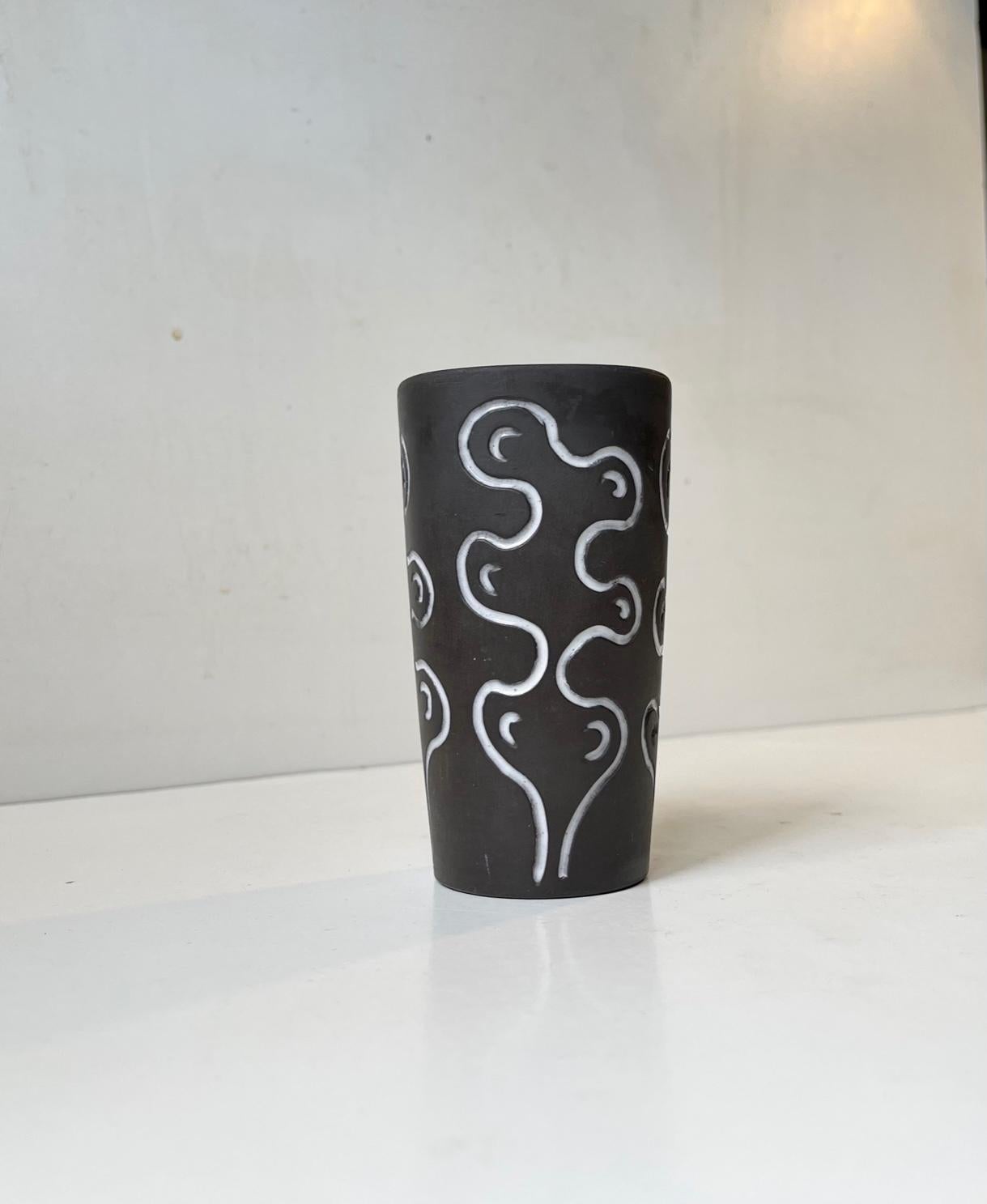 Ceramic vase decorated in glaze with abstract white motif and interior teal green glaze. Designed by the danish ceramist Helge Østerberg and manufactured at his own studio during the 1960s. Its signed Ø and marked with country of origin to the base.